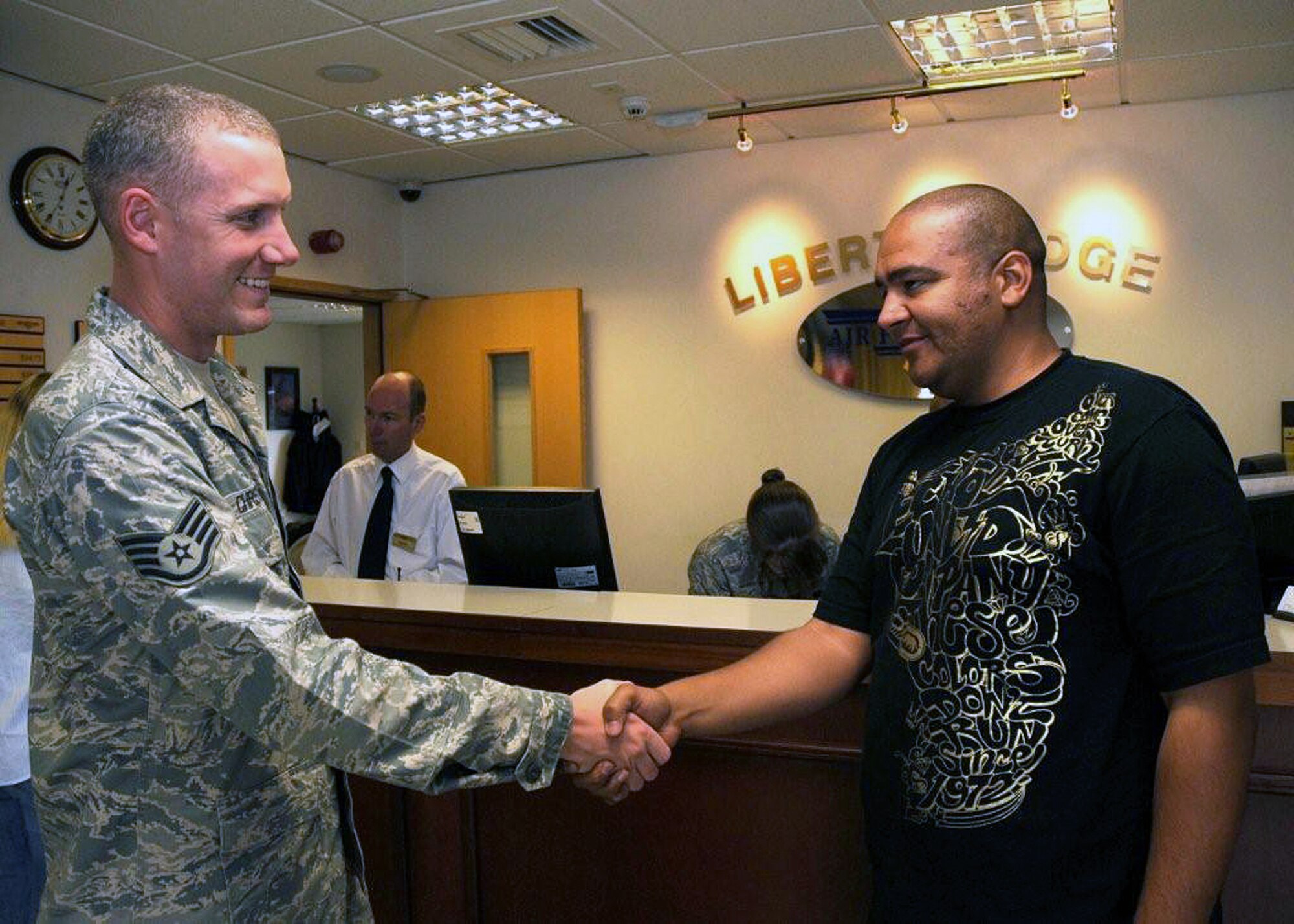 Staff Sgt. Keri Christensen (left), 48th Communications Squadron military postal clerk, welcomes Tech. Sgt. Mark Burleson, 48th CS military postal clerk, to RAF Lakenheath after his arrival August 25, 2009. The sponsorship program is designed to provide newcomers with a personal contact at their new base. Sponsors assist newcomers by arranging necessities such as lodging and a post box. The program is the first line of defense for inbound Airmen and their families.  (U.S. Air Force photo/A1C Eboni Knox)