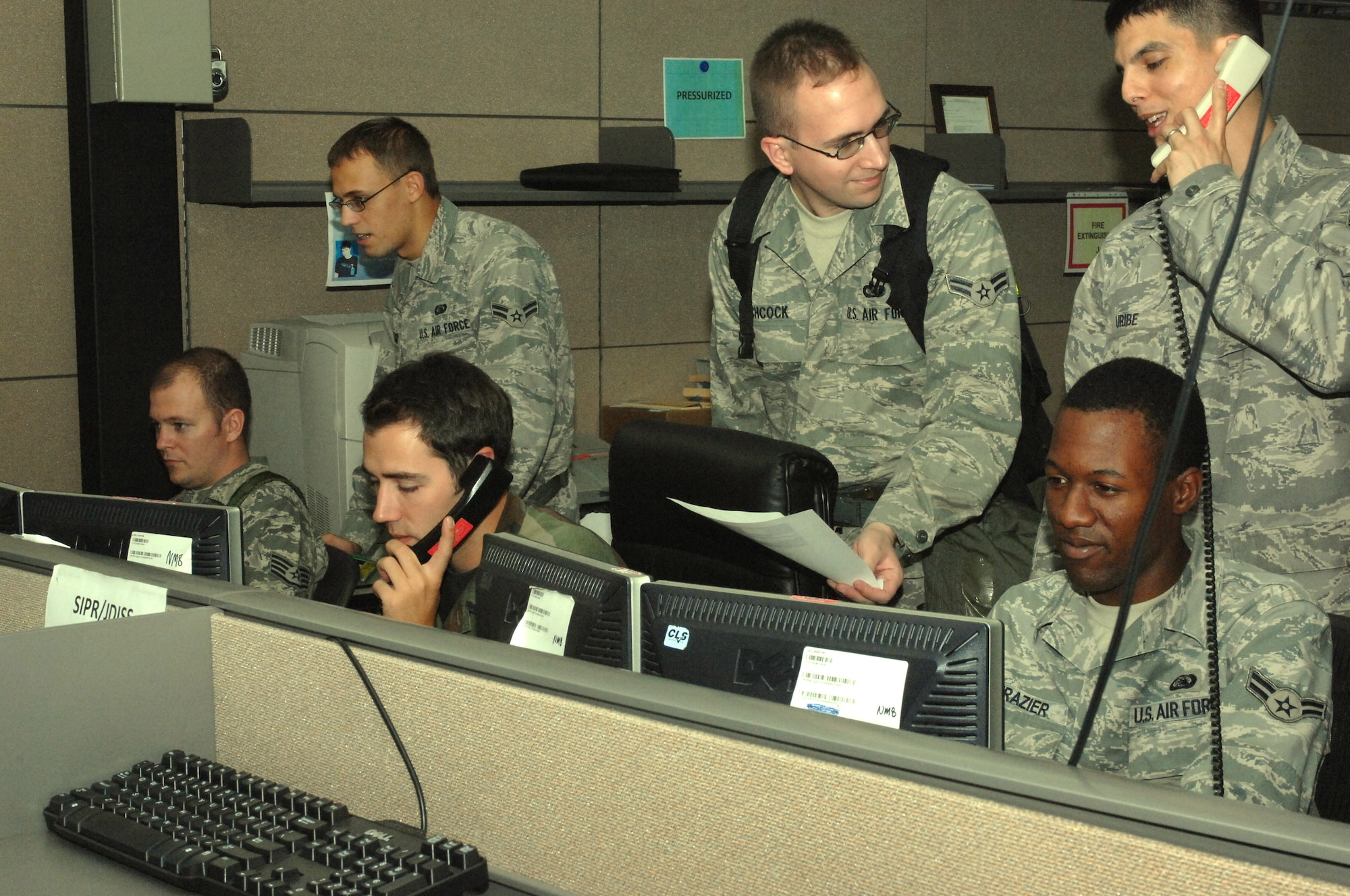 Airmen at the 607th Air and Space Communications Squadron's Comm Focal Point triage support requests August 26 as phones ring off the hook during the annual exercise ULCHI FREEDOM GUARDIAN 2009. The 607 ACOMS was operational 24 hours a day during the two week exercise, utilizing permanent party Airmen and augmentees from across the Air Force. (U.S. Air Force photo/Airman 1st Class Elliott Sprehe)