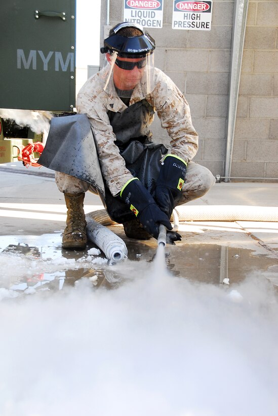 Cpl. Geoffrey Heard, Marine Aviation Logistics Squadron 13 cryogenics technician, freezes water on the ground with liquid nitrogen for quality testing at the cryogenics lab at the Marine Corps Air Station in Yuma, Ariz., Aug. 27, 2009.