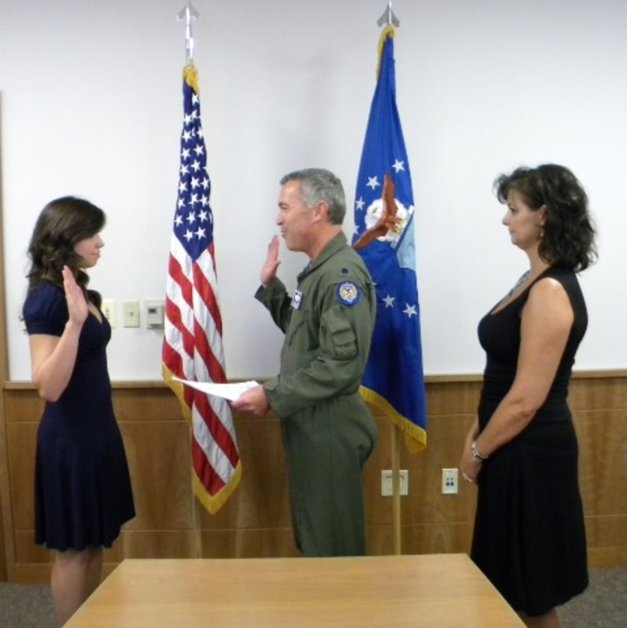 Air Force Reservist, Lt. Col. John Klimmek with the 940th Wing Operations Group swears in his daughter Megan Klimmek on Aug. 21 as her mother, Roxanne, looks on.   In October, Megan will attend basic training at Lackland Air Force Base, Texas, with follow-on training at Goodfellow Technical Training Center in San Angelo, Texas.  Once her training is complete, Megan will return to Beale and be assigned to the 50th Intelligence Squadron. (U.S. Air Force Photo/ Dana Lineback)

