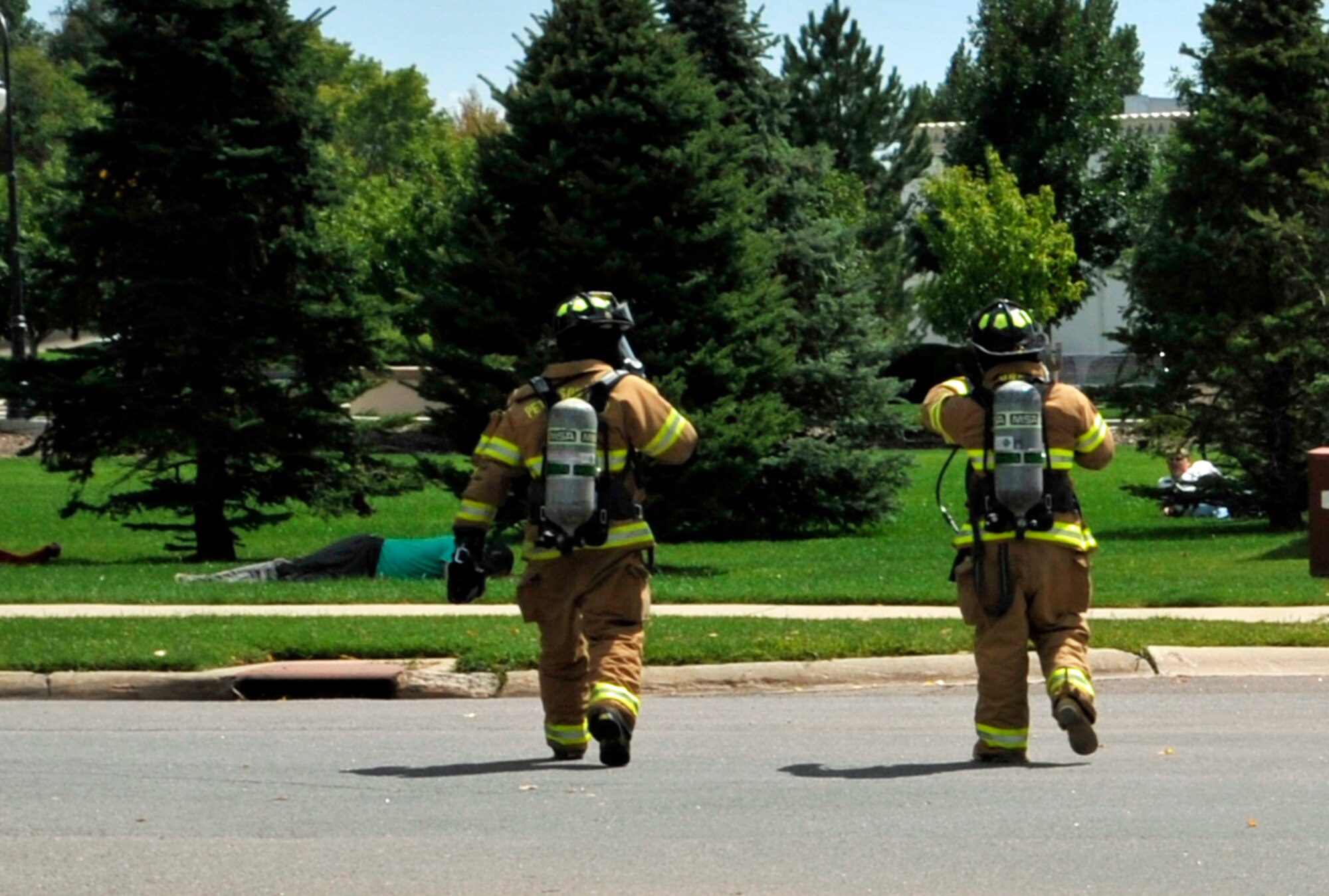 PETERSON AIR FORCE BASE, Colo. -- Two 21st Civil Engineer Squadron firemen rush to aid Condor Crest exercise “victims” following a staged multi-vehicle accident which resulted in a chemical spill at the intersection of Ent Avenue and Peterson Boulevard Aug. 26. The vehicle accident and resultant chemical spill scenario was the centerpiece of the wing’s four-day Condor Crest exercise. The 21st Space Wing holds Condor Crest exercises throughout the year to evaluate internal processes for effectiveness and efficiency. (Air Force photo by Rob Lingley)