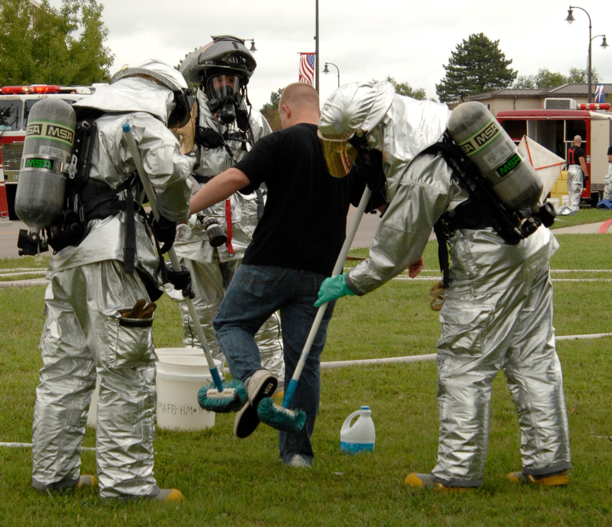 Firefighters from the 22nd Civil Engineer Squadron decontaminate Airman 1st Class John Haddem, 349th Air Refueling Wing, a mock blister-agent victim, during a major accident response exercise at McConnell Air Force Base, Kan., Aug. 27. Firefighters practiced decontaminating around 12 victims during the exercise to prepare them for possible real-world events. (U.S. Air Force photo/Senior Airman Laura Suttles)