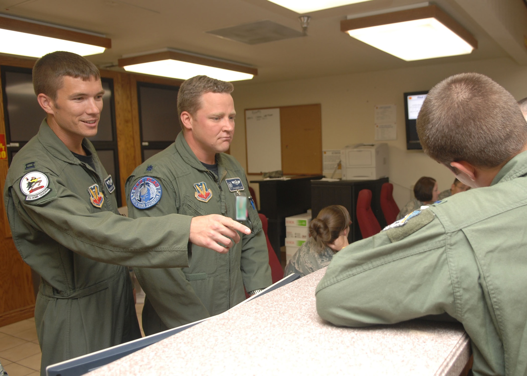 NELLIS AIR FORCE BASE, Nev. -- Lt. Col. Tyrell Chamberlain, 20th Bomb Squadron commander, and Capt. Warren Carroll, 20th BS pilot, man the operations desk at Red Flag 09-5 at Nellis Air Force Base, Nev., Aug. 26.  Colonel Chamberlain is the acting mission director for day and has Captain Carroll shadowing him for training.  Red Flag is an intense two-week combat scenario exercise where flyers integrate with other airframes and units to perform at large force employment. (U.S. Air Force photo by Staff Sgt. Sarah Stegman)