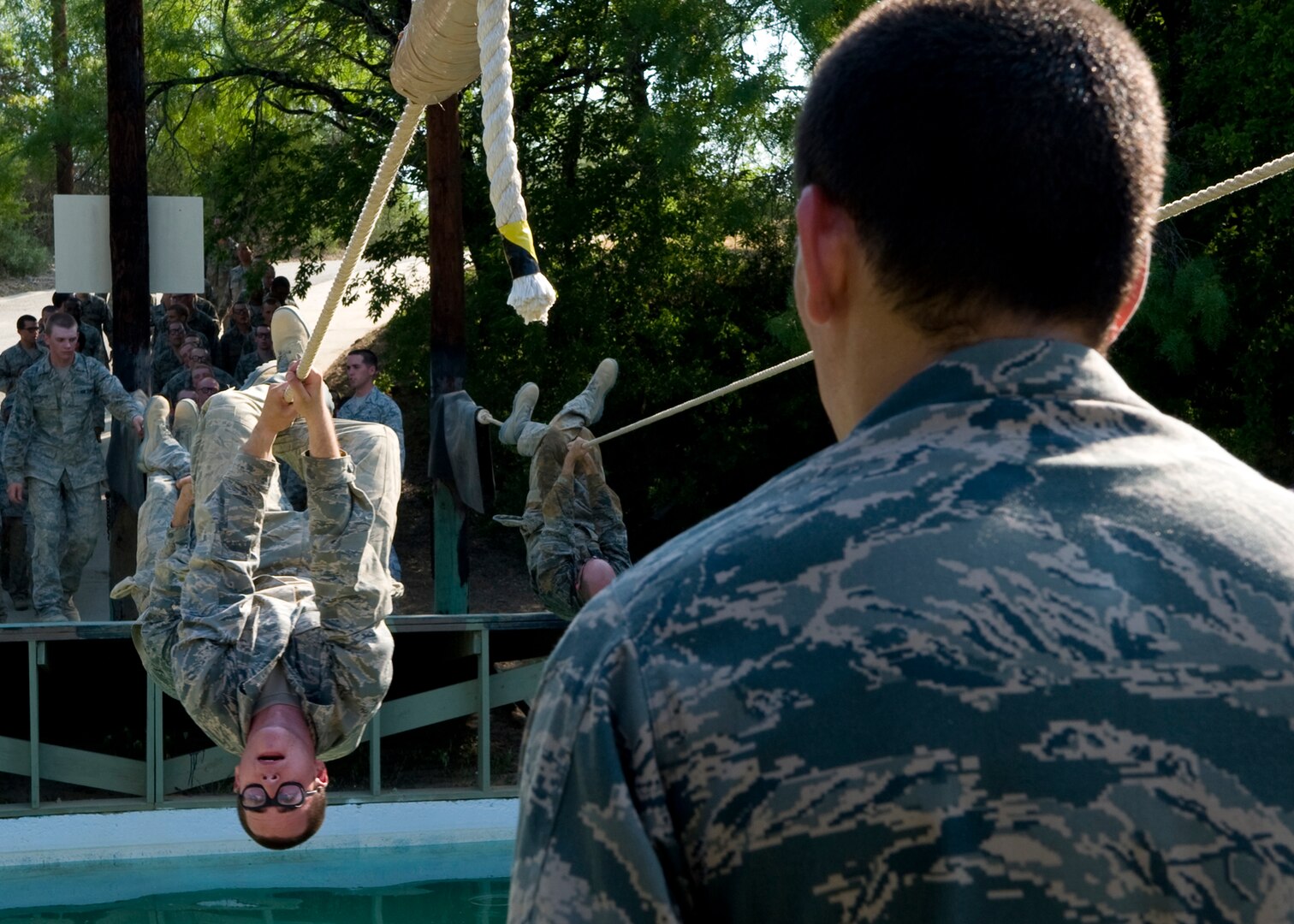 An Air Force Basic Military Training trainee holds on tightly as he crosses over the water pit. In addition to fitness training and military studies, BMT trainees are  taught foundational Air Force information including core values, customs and
courtesies, and basic policies and procedures. (U.S. Air Force photo/Benjamin Faske)