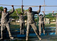 Air Force Basic Military Training trainees try and keep their balance as they pass over the water pit during their fourth week of training. By the end of their eighth and final week of training, trainees will have earned the privilege of wearingtheir blue uniform and being called an Airman. (U.S. Air Force photo/Benjamin Faske)