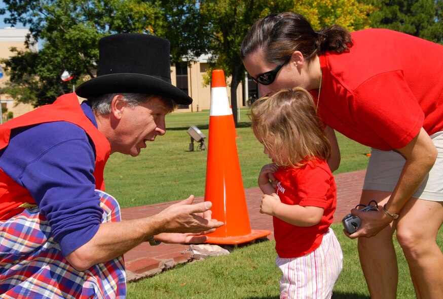 Pinnacle-Hunt sponsored a “back to school” carnival Aug. 22 for base residents at the Maxwell Air Park. Dependents were able to enjoy pony rides, games, prizes, a dunking booth and food and drinks. Magician Gary Ledbetter shows Sarah, daughter of Lt. Col. Bob Munson, a quarter that he found behind her ear as mom Laura Munson looks on. (U.S Air Force photo/Bud Hancock)