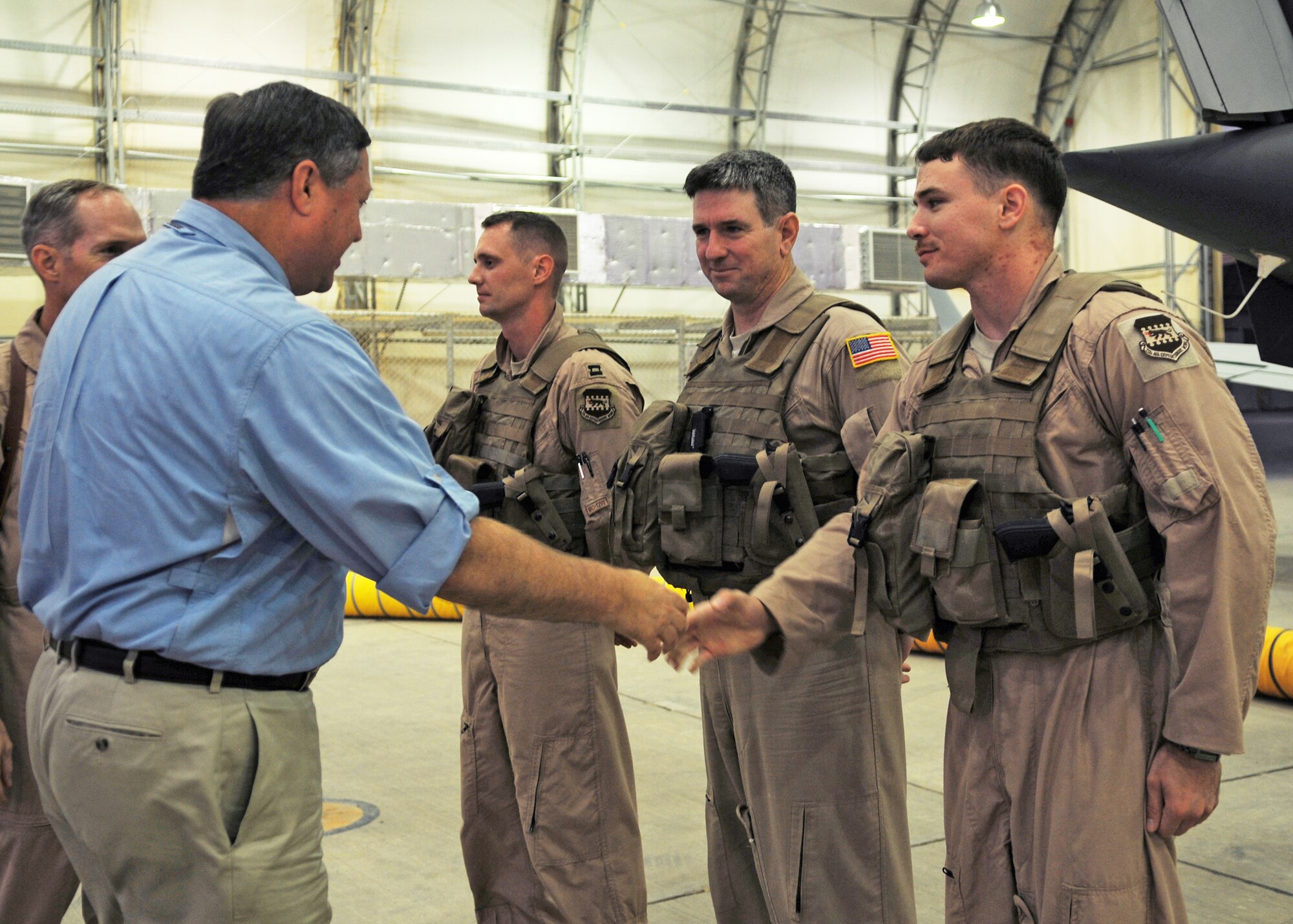 Secretary of the Air Force Michael Donley greets an MC-12 Liberty aircrew, Aug. 27 during a tour of Joint Base Balad, Iraq.  Capt. Matthew Eldredge (from left), Senior Master Sgt. Bruce Hunter and Senior Airman Matt Jones are assigned to the 362nd Expeditionary Reconnaissance Squadron.  A 362nd ERS aircrew flew the MC-12's first combat mission June 12.  The unit now operates six MC-12s and provides real-time full-motion video and signals intelligence that allows military leaders to make rapid battlefield decisions. Secretary Donley visited the base to meet with the Airmen there and also to observe the MC-12 mission.  (U.S. Air Force photo/Staff Sgt. Heather M. Norris)