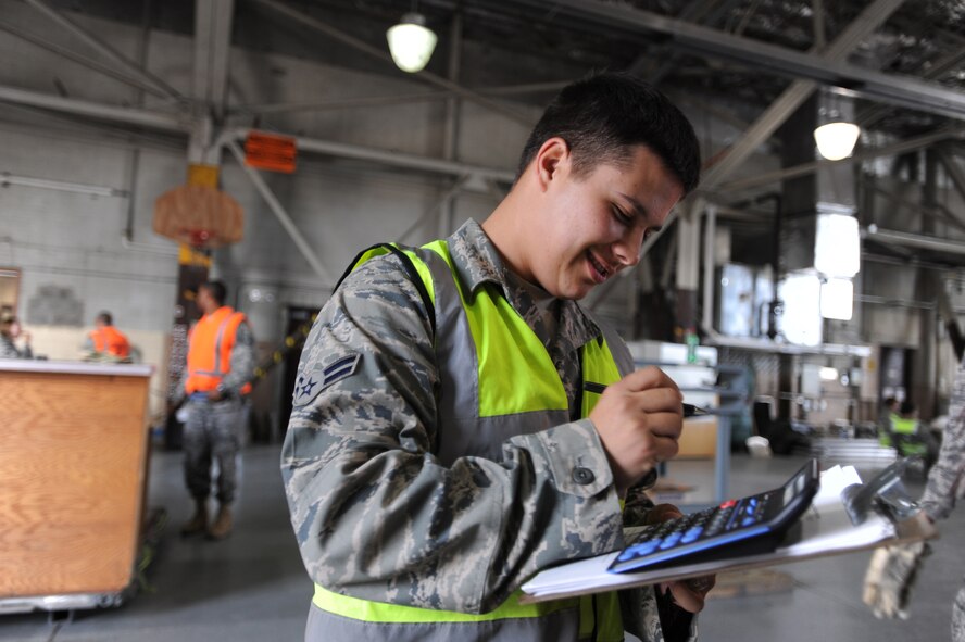 During an exercise Aug. 27 at Grand Forks Air Force Base, “Operation Intital Response," at the processing center Airman 1st Class Michael Nelson, 319th Logistics Readiness Squadron, tallies up the scale weight for a “Light All”. (U.S. Air Force photo By Staff Sgt. Suellyn F. Nuckolls)