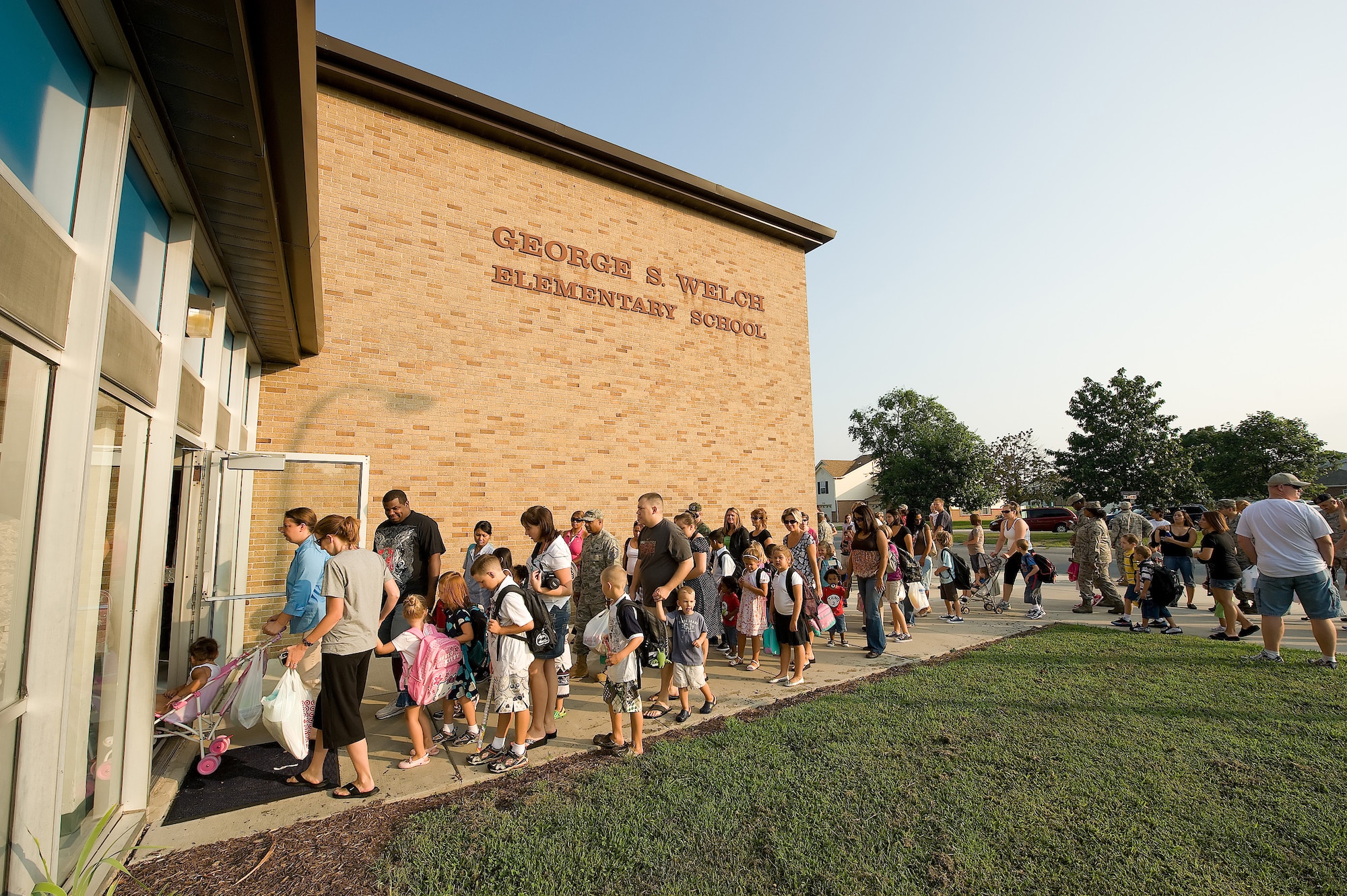Children line up with their parents to enter George S. Welch Elementary School for the first day of school Aug. 26. With the start of the new school year, drivers should be more alert for pedestrians as many children walk or bike to school. (U.S. Air Force photo/Jason Minto)