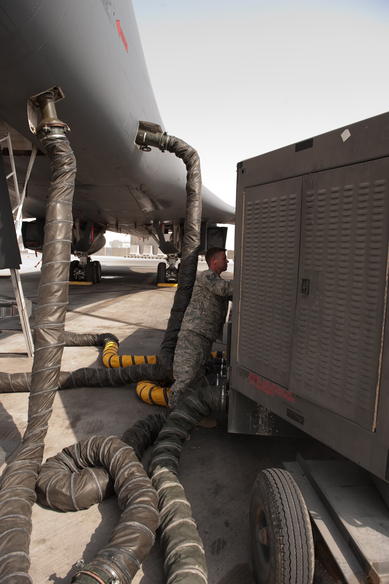 Tech. Sgt. Jesse Maddox, 379th Expeditionary Maintenance Squadron metals technology floor supervisor, installs a splitter on an air conditioner unit, Aug. 26, in Southwest Asia. Sergeant Maddox, along with his co-workers, designed and manufactured a custom splitter that limits the number of AC units supporting a B-1B Lancer from multiple units down to a single AC unit. Sergeant Maddox is a native of Clearwater, Fla. and is deployed from Ellsworth Air Force Base, S.D.  in support of Operations Iraqi and Enduring Freedom.  (U.S. Air Force photo/Staff Sgt. Robert Barney)