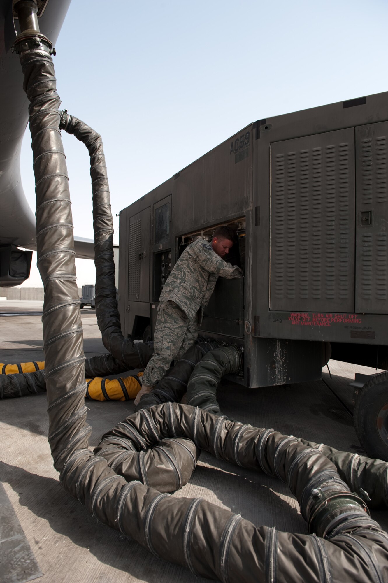 Tech. Sgt. Jesse Maddox, 379th Expeditionary Maintenance Squadron metals technology floor supervisor, installs a splitter on an air conditioner unit, Aug. 26, in Southwest Asia. Sergeant Maddox, along with his co-workers, designed and manufactured a custom splitter that limits the number of AC units supporting a B-1B Lancer from multiple units down to a single AC unit. Sergeant Maddox is a native of Clearwater, Fla. and is deployed from Ellsworth Air Force Base, S.D.  in support of Operations Iraqi and Enduring Freedom.  (U.S. Air Force photo/Staff Sgt. Robert Barney)