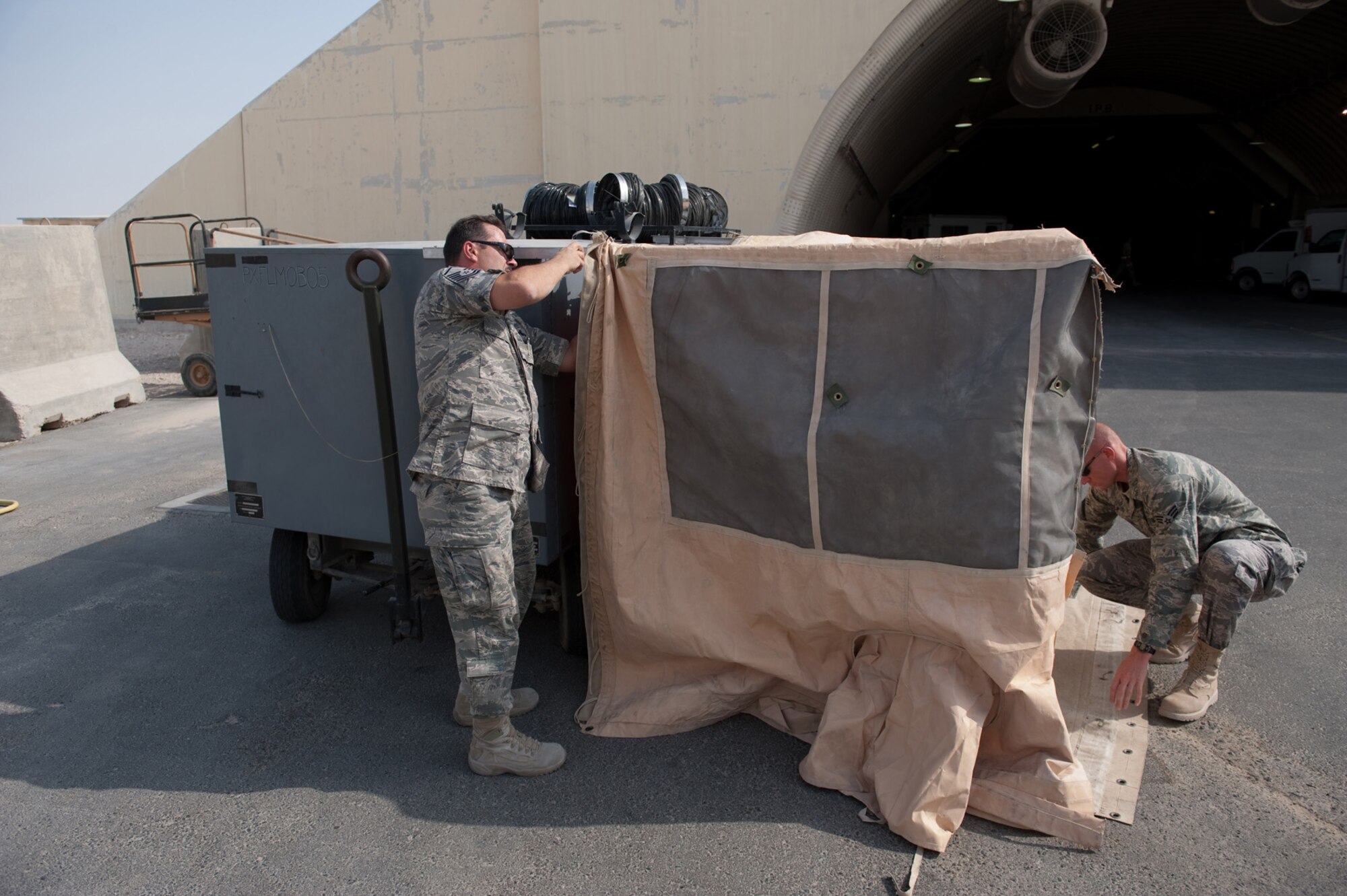 Left, Master Sgt. Gregg Thibodeau, 379th Expeditionary Maintenance Squadron metals technology section chief, and Senior Airman Shane Shanton, 379th Expeditionary Operations Support Squadron aircrew flight equipment journeyman, assemble a custom tent built, Aug. 22, from materials on hand at a cost of only $400. The tent is designed to provide shade and respite for flightline maintainers during work-rest cycles in extreme temperatures. Sergeant Thibodeau is a native of Rapid City, S.D., and deployed from Fairchild Air Force Base, Wash. Airman Shanton is a native of Jackson, Ohio and deployed from Kirtland AFB, N.M. Both servicemembers are deployed n support of Operations Iraqi and Enduring Freedom. (U.S. Air Force Photo/ Staff Sgt. Robert Barney) 