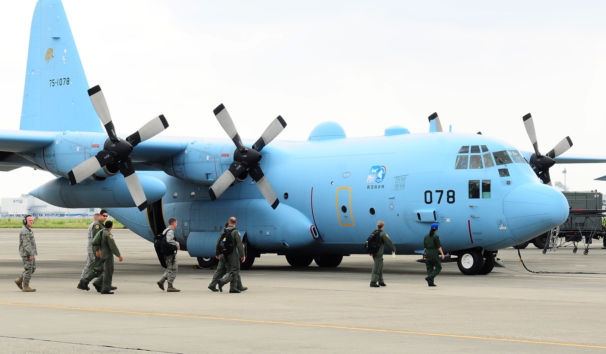 KOMAKI AIR BASE, Japan -- Members of the 36th Airlift Squadron and the 374th Maintenance Squadron from Yokota Air Base, Japan, prepare to board a Japan Air Self-Defense Force C-130 during a Bilateral Airlift Training Program visit Aug. 26. The program is designed to enhance interoperability, build working relationships, and explore joint training/operations opportunities. During the visit, Yokota Airmen flew aboard two JASDF C-130s while maintainers toured the base's ground facilities. (U.S. Air Force photo/Airman 1st Class Sean Martin)