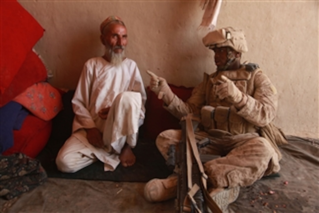 U.S. Marine Corps Cpl. Mahmoud Bowler, a warehouse clerk with Headquarters Battery, 3rd Battalion, 11th Marine Regiment, speaks with an Afghan farmer in Helmand province, Afghanistan, on Aug. 18, 2009.  The Marines are deployed with Regimental Combat Team 3, to conduct counterinsurgency operations in partnership with Afghan security forces in southern Afghanistan.  