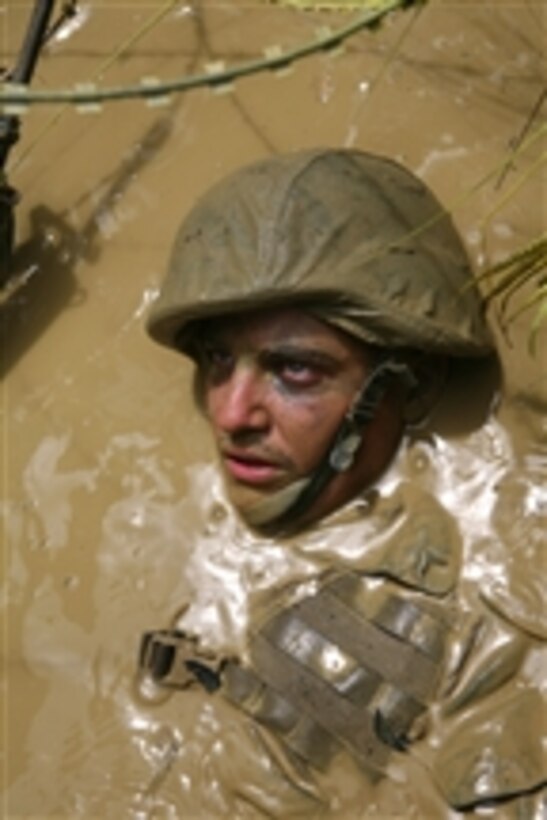 U.S. Marine Corps Pfc. Ross Simpson, with 7th Communications Battalion, advances through an obstacle course at the Jungle Warfare Training Center at Camp Gonsalves, Okinawa, Japan, on Aug. 21, 2009.  Jungle Warfare Training Center training shows service members how to become effective war fighters in a jungle environment by teaching them land navigation, small unit leadership, patrolling and obstacle maneuvering.  