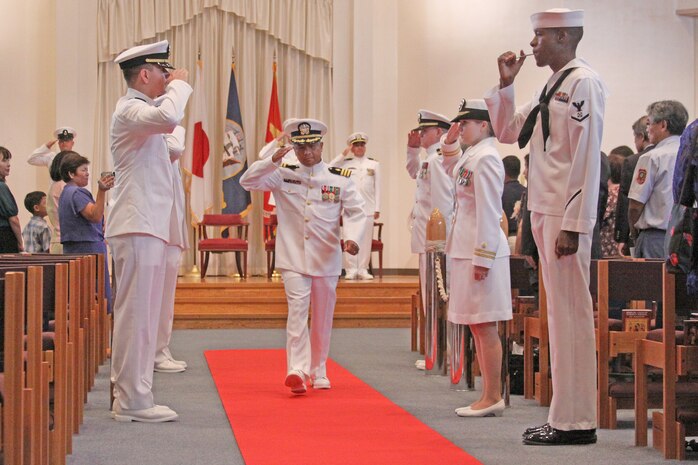 Cmdr. Cesar A. Odvina exits and salutes after assuming the position of officer-in-charge of the Branch Health Clinic during a change-of-charge ceremony at the station chapel here Aug. 28. At the change-of-charge ceremony, Odvina reminded the clinic staff of the challenges ahead and the importance of remaining vigilant and ready for those challenges.