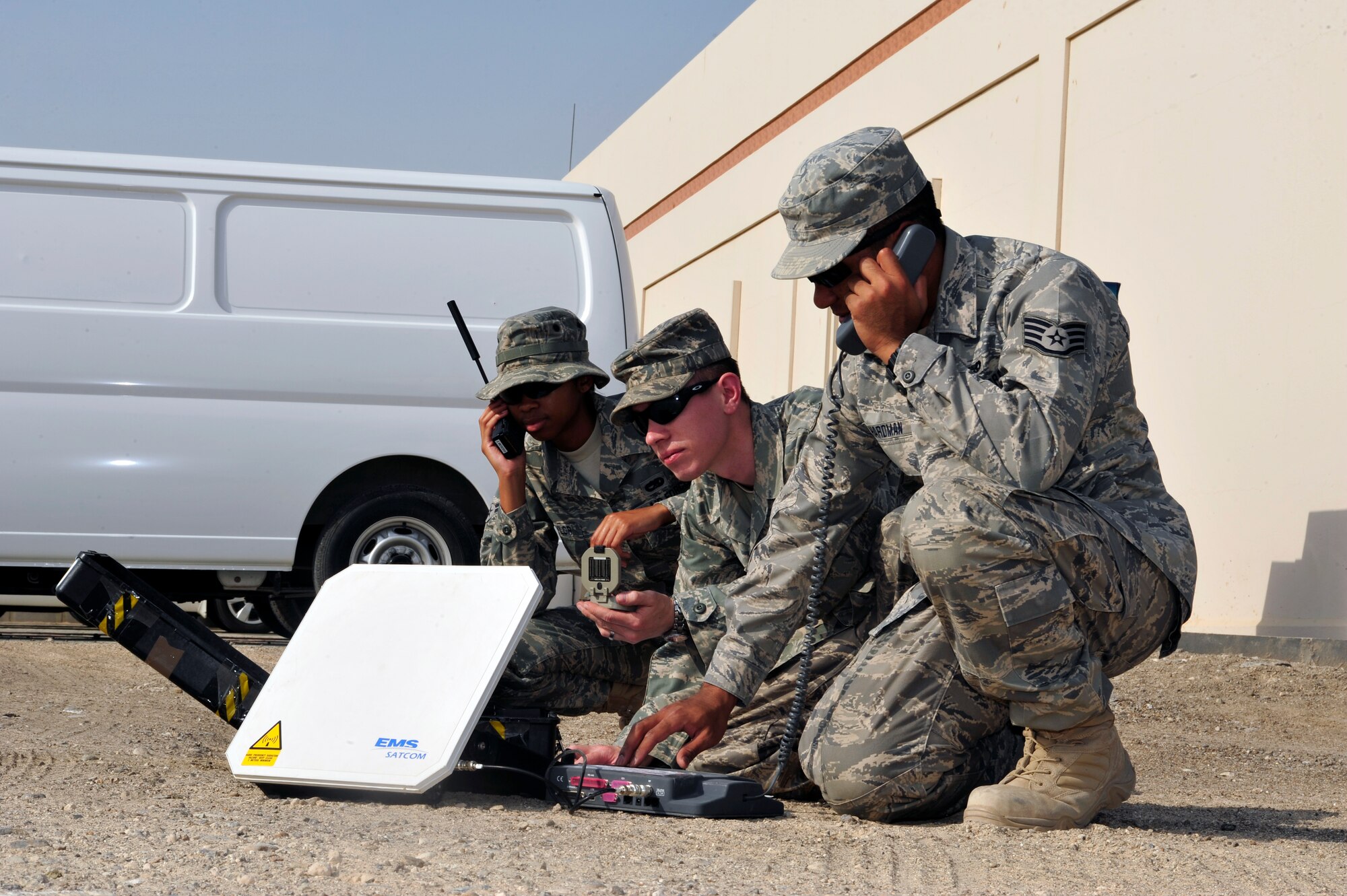 SOUTHWEST ASIA -Airman 1st Class Jamila Taylor, Senior Airman Jarrett Willis and Staff Sgt. Jason Hardman, 380th Expeditionary Communication Squadron, perform operational checks on satellite phones Aug. 26. Airman Taylor is deployed from Robins Air Force Base, Ga. Airman Willis is deployed from Royal Air Force Crowghton, England and hails from North Augusta, S.C. Sergeant Hardman is deployed from Hickam Air Force Base, Hawaii and grew up in Hilo, Hawaii. (U.S. Air Force photo/Tech. Sgt. Charles Larkin Sr)