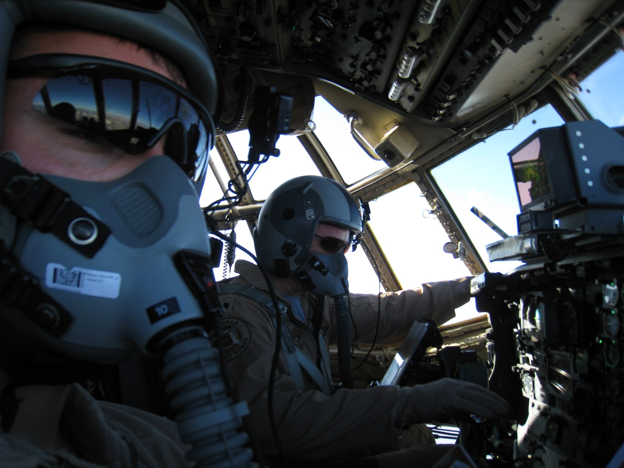 BAGRAM AIRFIELD, Afghanistan - Lt. Col. Tommy Atkinson (right) pilots a
C-130H Hercules over Northern Afghanistan on a humanitarian airdrop mission. The Airmen of the 774th Expeditionary Airlift Squadron have been dropping an average of five to eight tons of supplies and equipment per mission to Coalition forces and Afghan civilians in support of Operation Enduring Freedom. (U.S. Air Force photo)