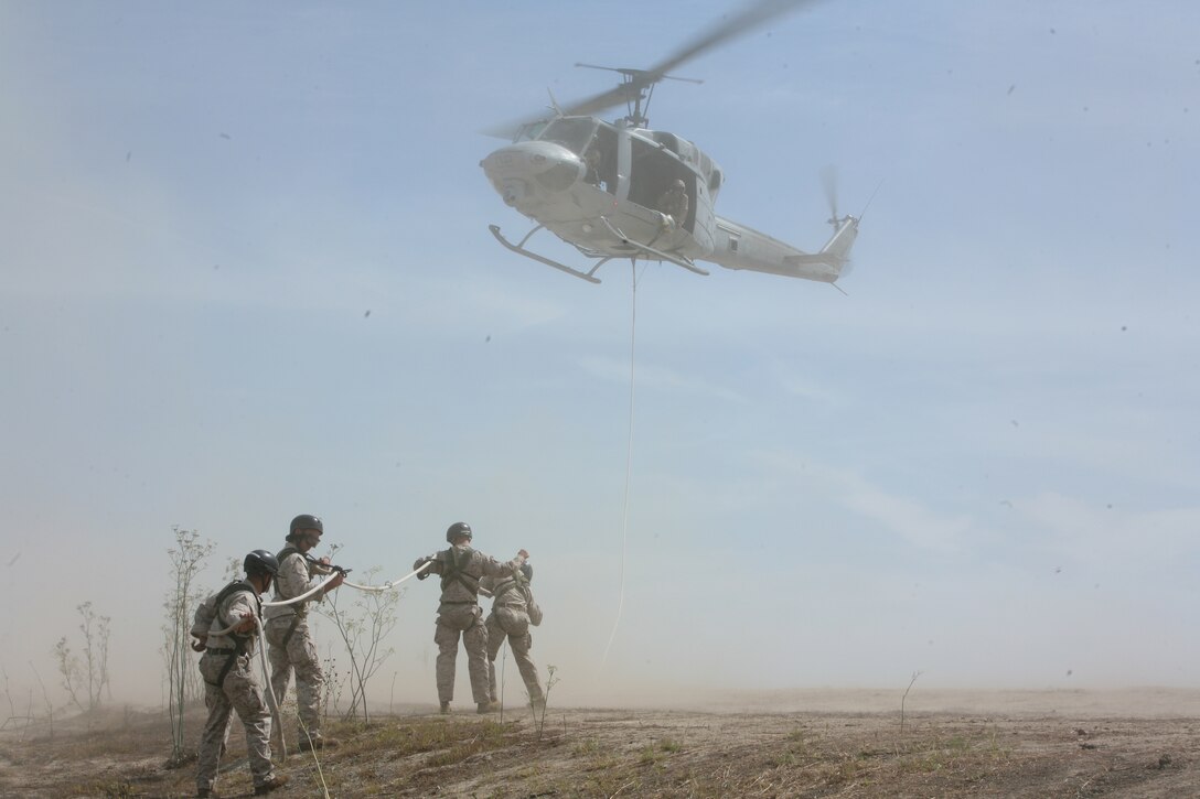 Marines from Marine Light Attack Helicopter Squadron 369 get strap in and get ready to perform Special Patrol Insertion and Extraction systems  during an air demonstration at HMLA-369 Family Day, Aug 29. More than 300 Marines and their families enjoyed the air demonstration and activities throughout the day.