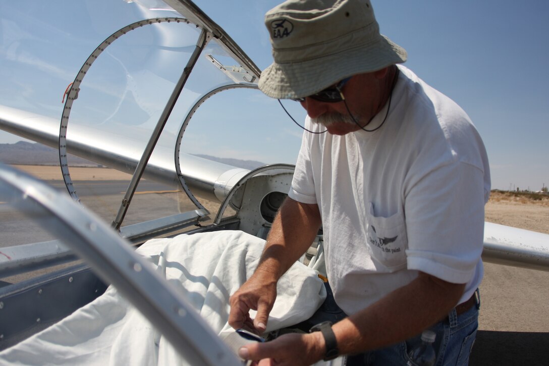 Ronald Renfro, the 29 Soaring Club president, checks the seatbelts on his glider before taking to the skies above the Twentynine Palms Airport Aug. 30. Renfro and fellow club members gather at the airport each Sunday to take their gliders for a spin.