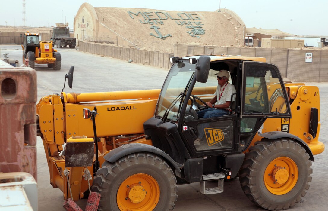 Ralph Mitchell, a material-handling equipment forklift operator, KBR contracting, moves a tri-wall box out of a container to assist 2nd Medical Logistics Company, 2nd Marine Logistics Group (Forward), stage more than $300,000 worth of gear in preparation for shipment to Afghanistan, Aug. 30, 2009, while aboard Camp Al Taqaddum, Iraq.  2nd MEDLOG is in the final stages of their seven-month deployment to Iraq in support of Operation Iraqi Freedom. (Official Marine Corps photograph by Gunnery Sgt. Katesha Washington)