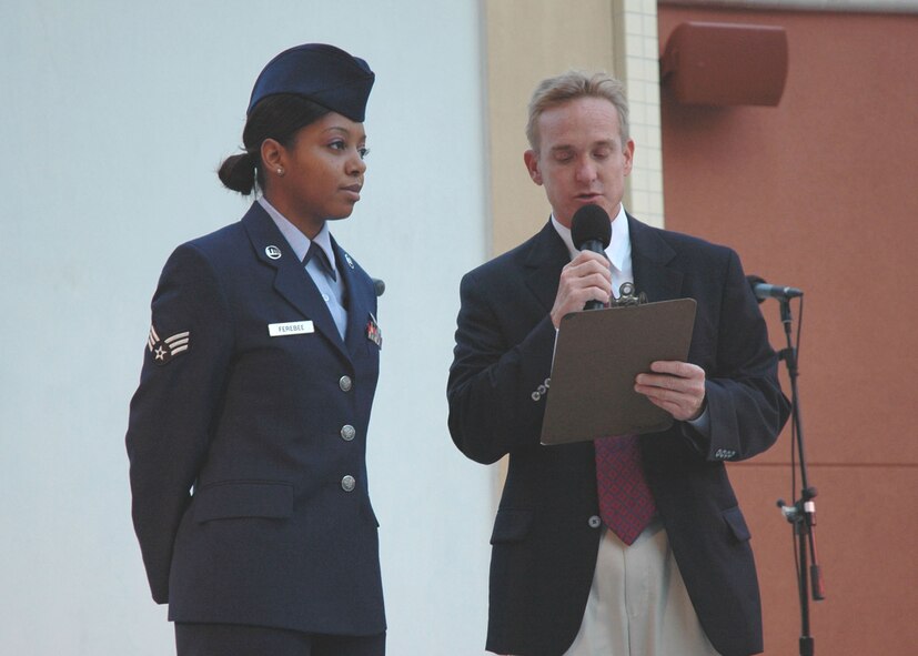 Air Force Reserve Senior Airman Randi Ferebee, 919th Mission Support Flight, stands proudly as Destin Mayor Craig Barker highlights her career achievements at Harborwalk Village's Red, White and Blue Celebration Aug. 20 at Destin Harbor.  The weekly patriotic salute event honors selected standouts from the local area's military bases.  Before an audience of nearly 300 local community, Duke Field and tourist wellwishers, she was presented a key to the City of Destin by the mayor. (U.S. Air Force photo/Dan Neely)