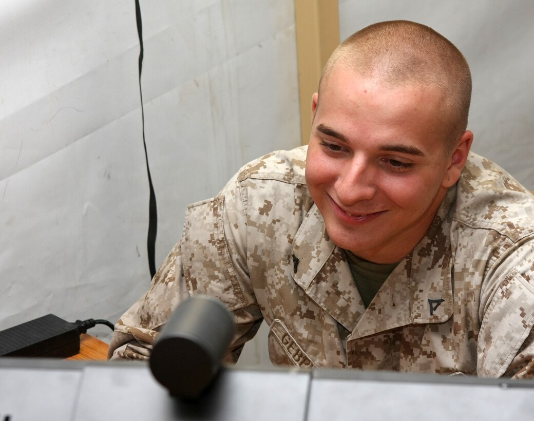 Lance Cpl. John C. Gebelein, a Virginia Beach native and an 81mm mortar forward observer with Kilo Company, Battalion Landing Team, 3rd Battalion, 2nd Marine Regiment, 22nd Marine Expeditionary Unit, says hello to his two-month-old daughter through a Video-Tele-Conference at Camp Buehring, Kuwait Aug. 30, 2009. The 22nd MEU is ashore in Kuwait conducting sustainment training while serving as the theater reserve force for U.S. Central Command.