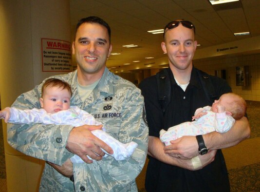 ANDERSEN AIR FORCE BASE, Guam - Tech. Sgt. Michael Knipmeyer, 36th Civil Engineer Squadron, and Tech. Sgt. Todd Tomlinson, 36th Security Forces Squadron, hold their daughters, Ava and Emily, after returning from deployment Aug. 5. (U.S. Air Force photo by Tech. Sgt. Rhonda Knipmeyer)