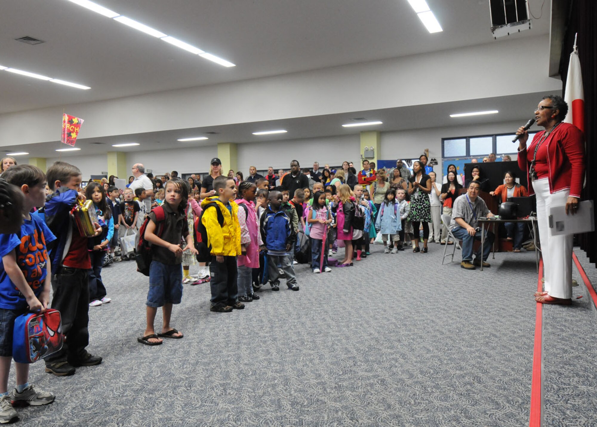 YOKOTA AIR BASE, Japan -- Hattie Phipps, Joan K. Mendel Elementary School principal, welcomes students back from summer vacation for the first official day of school Aug. 31. Before class began, the students gathered in the school library to participate in Radio Taiso, a form of stretching, known throughout the Japanese school system. The stretching is a daily routine to promote fitness and focus. (U.S. Air Force photo/Staff Sgt. Veronica Pierce) 