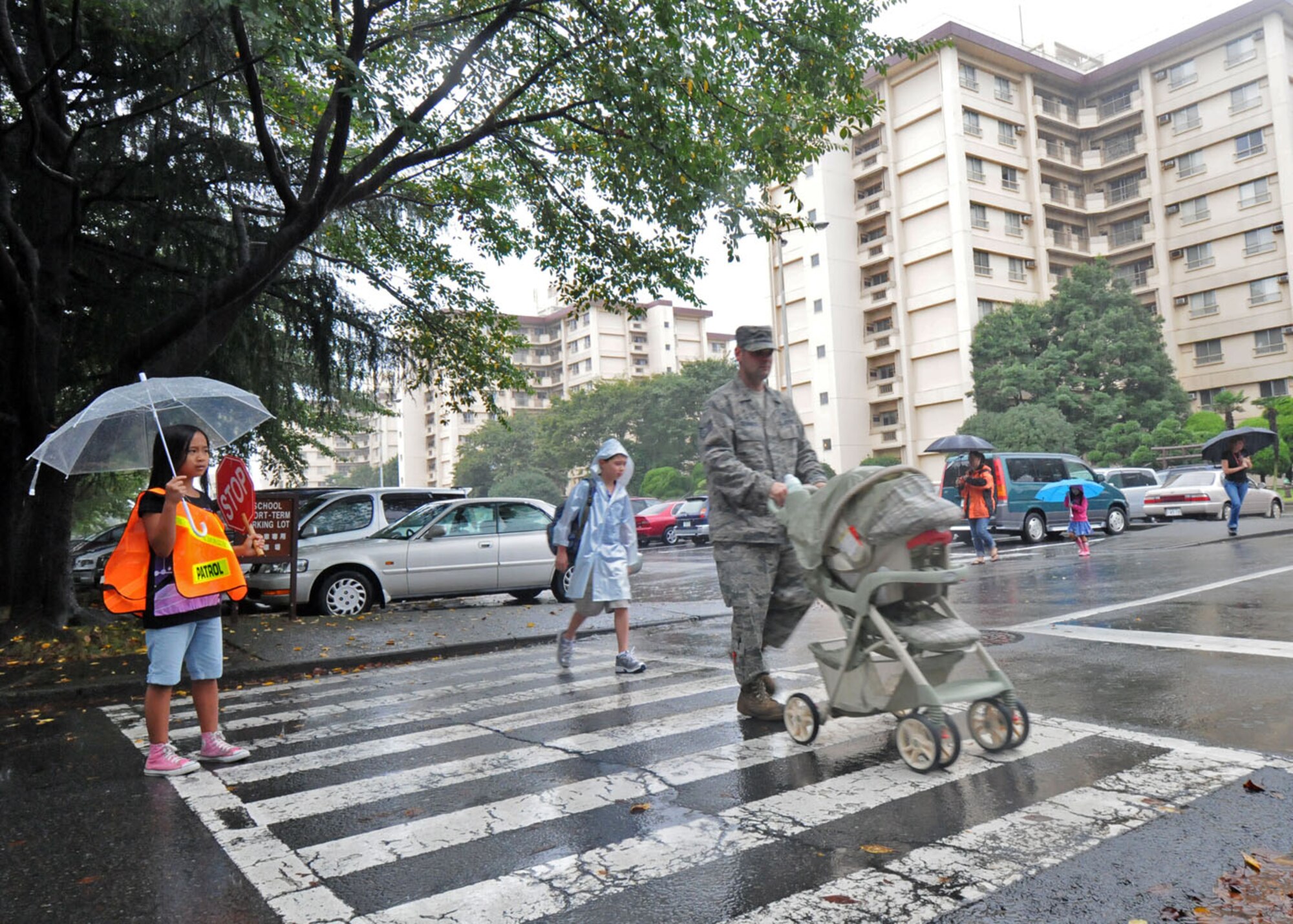 YOKOTA AIR BASE, Japan -- Hunny Joy Atchison, a student at Joan K. Mendel Elementary School on base, serves as a crossing guard on the first day of school Aug. 31. Students walked to school in a driving rain brought on by a tropical storm. The East Side elementary school, one of two on the base, has approximately 480 students registered this year. (U.S. Air Force photo/Staff Sgt. Veronica Pierce)