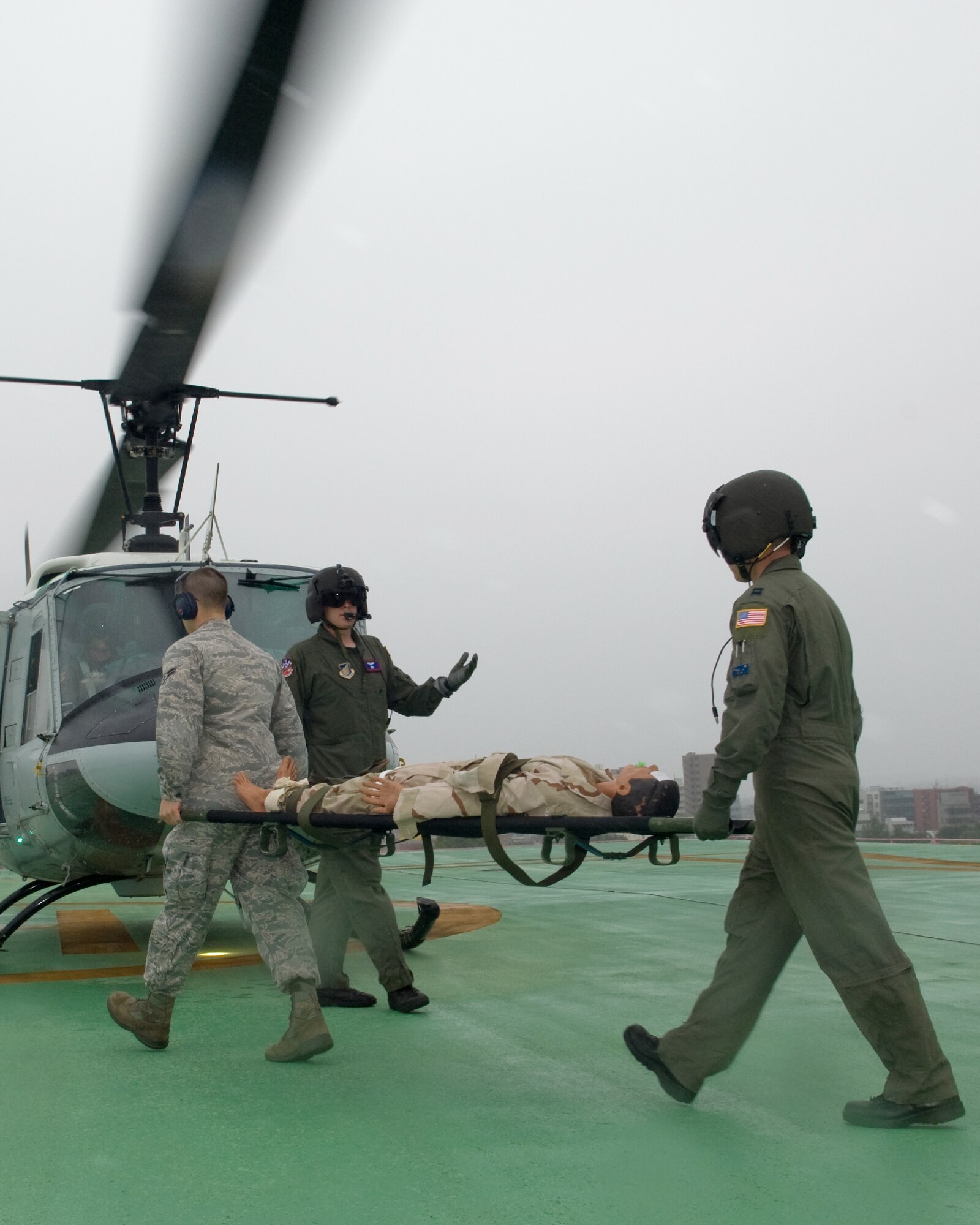 TACHIKAWA, Japan -- Capt. Kyle Jarnagin, 374th Medical Group flight surgeon, (right) and Airman 1st Class Gary Held, 374th MDG, move a simulated patient from  the Japan National Disaster Medical Center in Tachikawa to a UH-1N Huey from the 459th Airlift Squadron at Yokota Air Base,  Aug. 30 during a Tokyo Metropolitan Government Comprehensive Disaster Prevention Drill.  Yokota personnel practiced delivering medical supplies via helicopter to a Japan Self-Defense Forces hospital and transporting a patient from the hospital to the medical center in Tachikawa. (U.S. Air Force photo/Osakabe Yasuo)