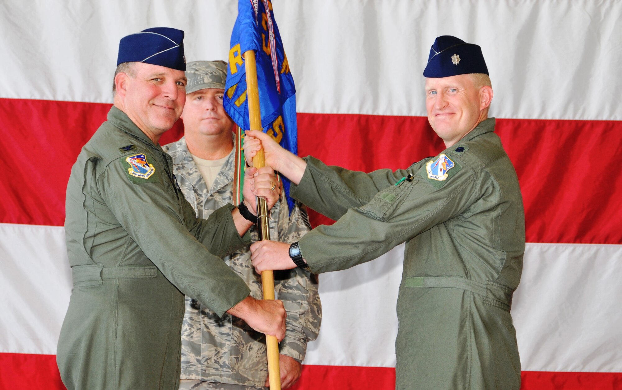 (Left) Col. Michael MacWilliam, 53rd Weapons Evaluation Group commander, presents the guidon to Lt. Col. Ryan Luchsinger, as he takes command of the 82nd Arial Target Squadron. The change of command ceremony took place Aug. 28 at Hangar 5. (U.S. Air Force photo/Lisa Norman)
