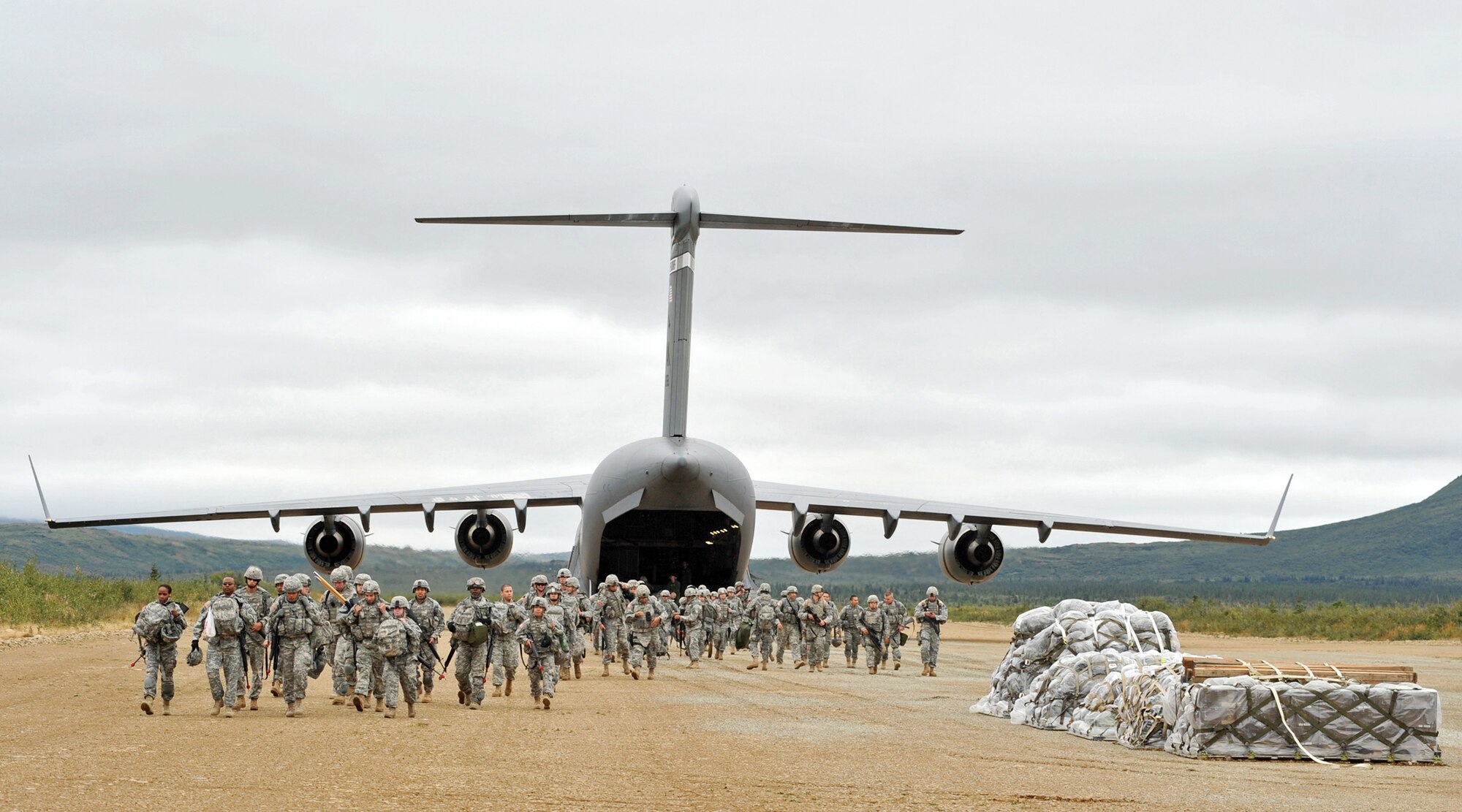Army Soldiers from the 17th Combat Service Support Battalion from Fort Richardson, Alaska, exit a C-17 Globemaster III from the 517th Airlift Squadron Aug. 24 at the Donnelly Landing Zone, Alaska. The aircraft and its aircrew assisted in deploying 120 Soldiers for Operation Arctic Response, an Army Emergency Deployment Readiness Exercise. Two C-17s flew to Donnelly and delivered five pallets, two Humvees, a trailer and a passenger carrier. (U.S. Air Force photo/Senior Airman Laura Turner)
