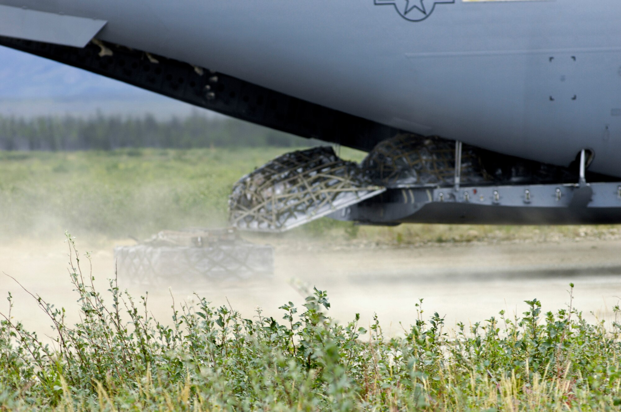 Pallets drop out of the back of a C-17 Globemaster III Aug. 24 at an unimproved landing strip near Elmendorf Air Force Base, Alaska. Airmen from the 517th Airlift Squadron and 249th Airlift Squadron participated in the Army's Operation Arctic Response to help deploy 120 Soldiers and supplies to the remote site. (U.S. Air Force photo/Airman 1st Class Christopher Gross) 
