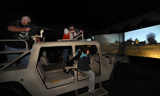 OFFUTT AIR FORCE BASE Neb. --  Attendees of the 2009 Defenders of Freedom Open House and Air Show participate in simulated combat inside the Virtual Army Experience here Aug. 29. The Virtual Army Experience consisted of military vehicles including a Blackhawk helicopter, loaded with modified machine guns that could be electronically fired at a giant screen displaying mock combat scenarios. Participants were graded on their accuracy and team work as they responded to various combat situations. U.S. Air Force Photo by Josh Plueger