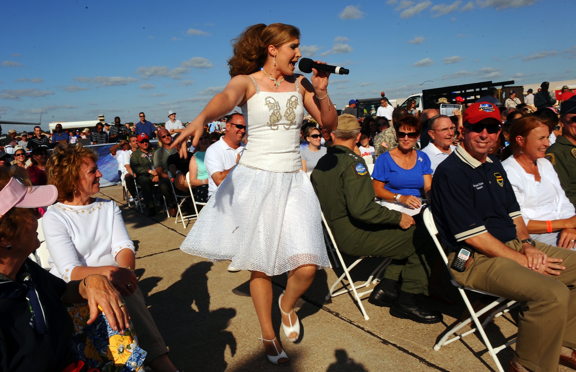 OFFUTT AIR FORCE BASE Neb. -- Staff Sgt. Naomi Keen, a vocalist with Tops in Blue, entertains a large crowd during a performance at the 2009 Defenders of Freedom Open House and Air Show here Aug. 29. Tops in Blue, also known as the Air Force's expeditionary entertainers, performed numerous songs during the show including "Neon Rainbow,"  "Chicken Fried" and "God Bless the USA."  U.S. Air Force Photo by Josh Plueger