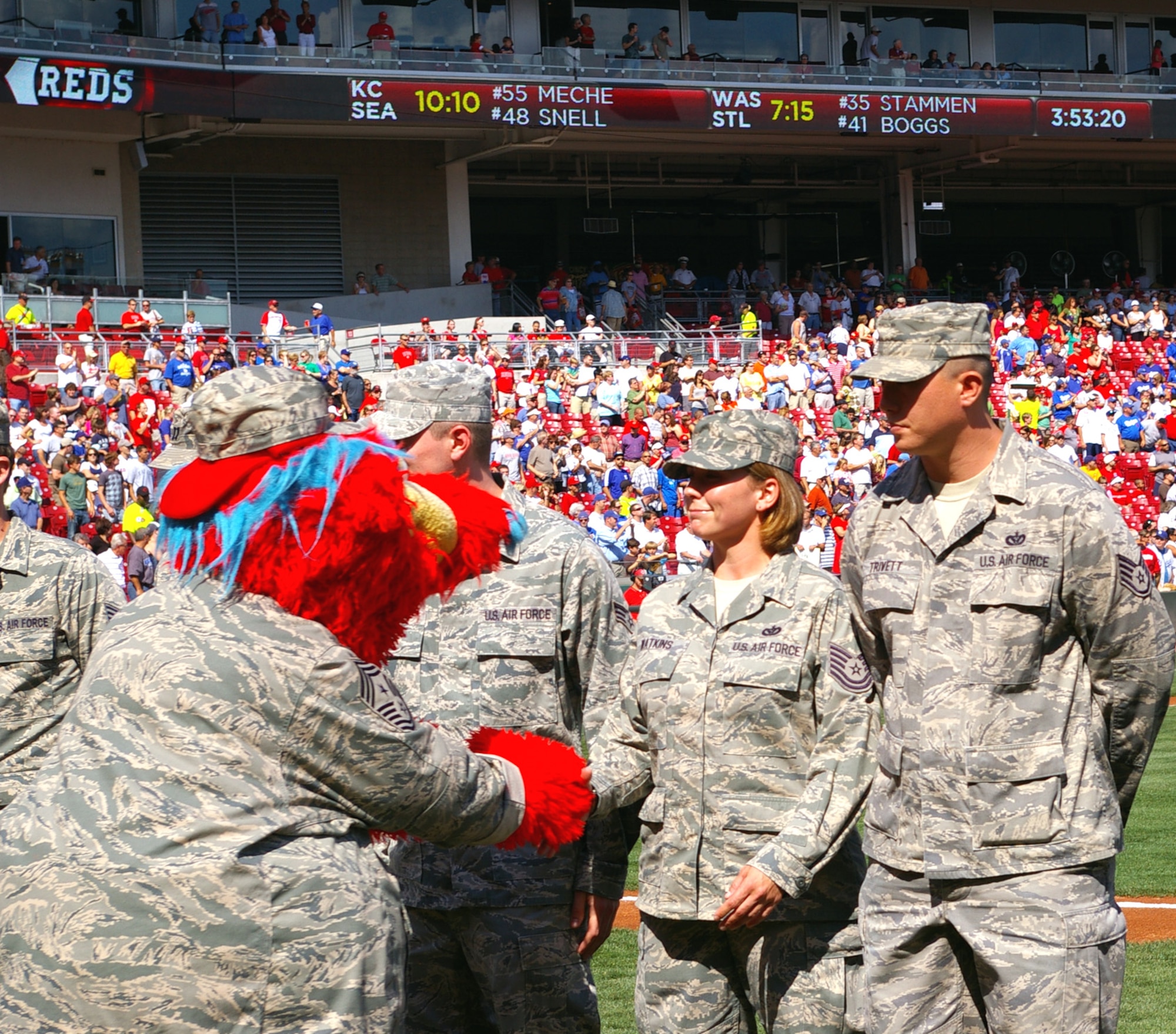 CINCINNATI, Ohio - Tech. Sgt. Tiffany Watkins, 445th Civil Engineer Squadron, shakes hands with mascot Grapper while on the field at the Cincinnati Reds' Great American Ball Park.  Sergeant Watkins and Staff Sgt. Scott Trivett (right), both of the civil engineer squadron, were recognized during the pregame ceremony, Aug. 29, 2009, for recently returning from a deployment.  The Saturday game was Cincinnati Reds Military Appreciation Day. (Air Force photo/Laura Darden)  