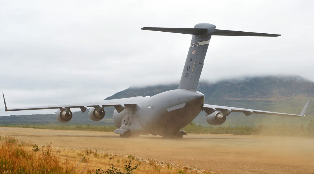 A C-17 Globemaster III kicks up a cloud of dust as it lands at an unimproved air strip Aug. 24 near Elmendorf Air Force Base, Alaska.  The crew from the 517th Airlift Squadron assisted in deploying 120 Soldiers from the 17th Combat Service Support Battalion on Fort Richardson during Arctic Response. Arctic Response is an Army emergency deployment readiness exercise. (U.S. Air Force photo/Senior Airman Laura Turner)