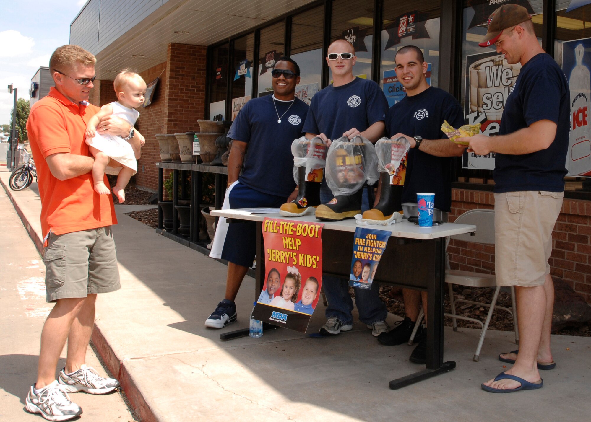 CANNON AIR FORCE BASE, N.M. -- Chief Master Sgt. Bill Turner, holding his 9-month old daughter Regan, meets with Cannon firefighters Aug. 30 as they collect donations for the Fill the Boot campaign in the fight against multiple sclerosis. Chief Turner will assume duties as the 27th Special Operations Wing command chief. Airmen collecting for the campaign, from left to right, are: Senior Airman Jonathan Johnson, Staff Sgt. Anthony Mock, Airman 1st Class Michael Rodriguez and Senior Airman Ken Thornton (U.S. Air Force photo by Greg Allen)