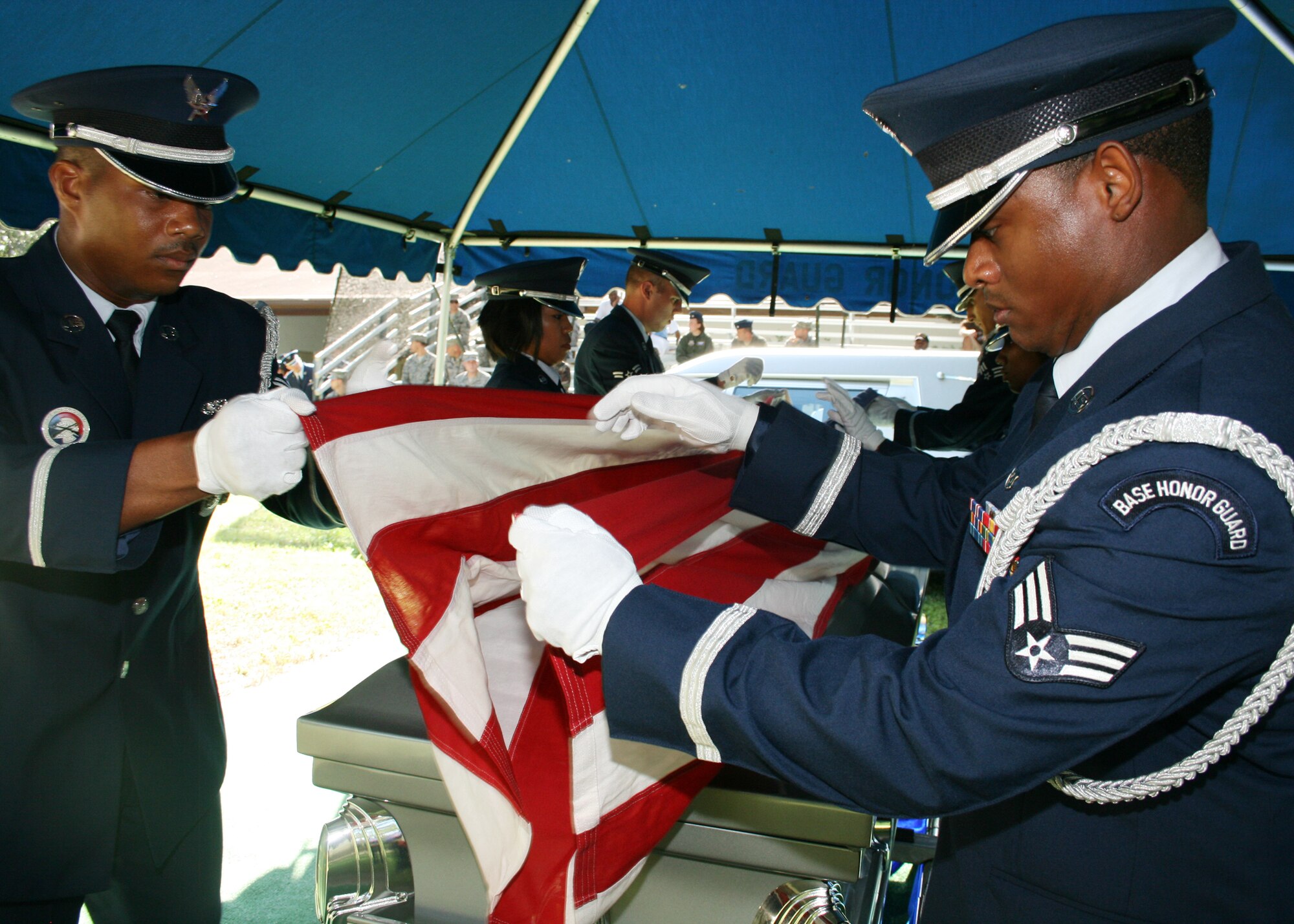 (Left) Staff Sgt. Isaiah Graham and Senior Airman Michael Gray fold the flag during a full military honors funeral demonstration Aug. 28 as part of the honor guard graduation. 15 Airmen graduated and will serve a six month tour as base honor guard before returning to their previous career fields. Honor guard classes graduate every three months.  (U.S. Air Force photo/2nd Lt. Andrew Caulk.)