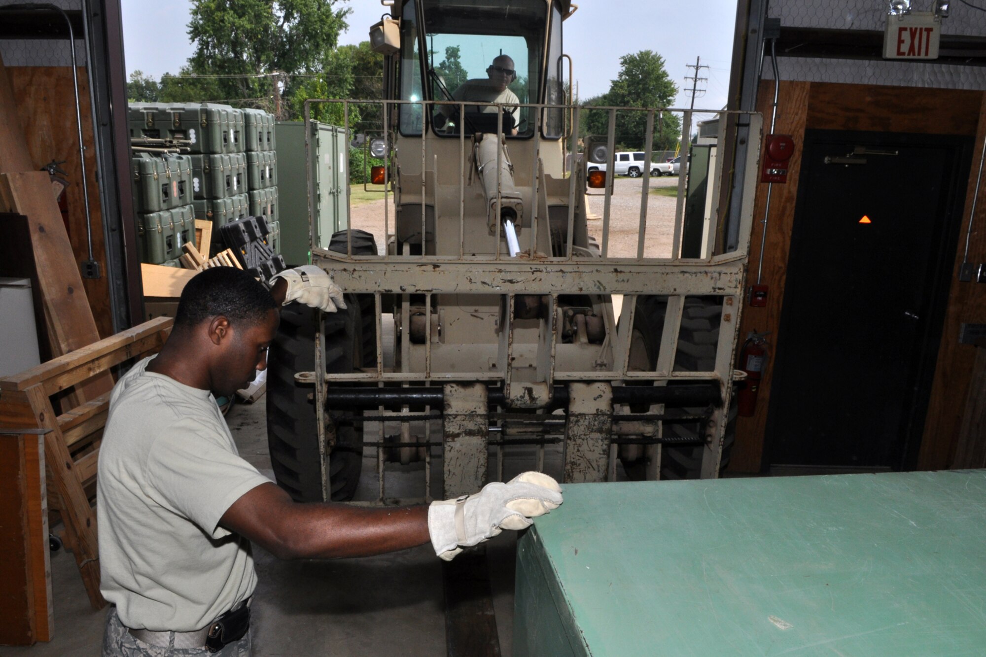 Staff Sgt. Frank Jackson, knowledge operations manager, directs Technical Sgt. Roy Stockinger, structural craftsman, as he prepares to move a conex container full of spare parts and equipment with a 10K all-terrain forklift at Barksdale Air Force Base, La., August 27, 2009. Both Sergeants are members of the 917th Civil Engineer Squadron. Room is being made in the CE warehouse located behind the 917th Wing Headquarters building at Barksdale for contractors who will construct training classrooms, a storage area and a bathroom inside the building. The Global Strike Command is paying for the renovation since they will soon occupy the office space the 917th CES recently vacated.  Construction is schedule for two weeks and should be completed by the September UTA. (U.S. Air Force photo/Tech. Sgt. Jeff Walston)