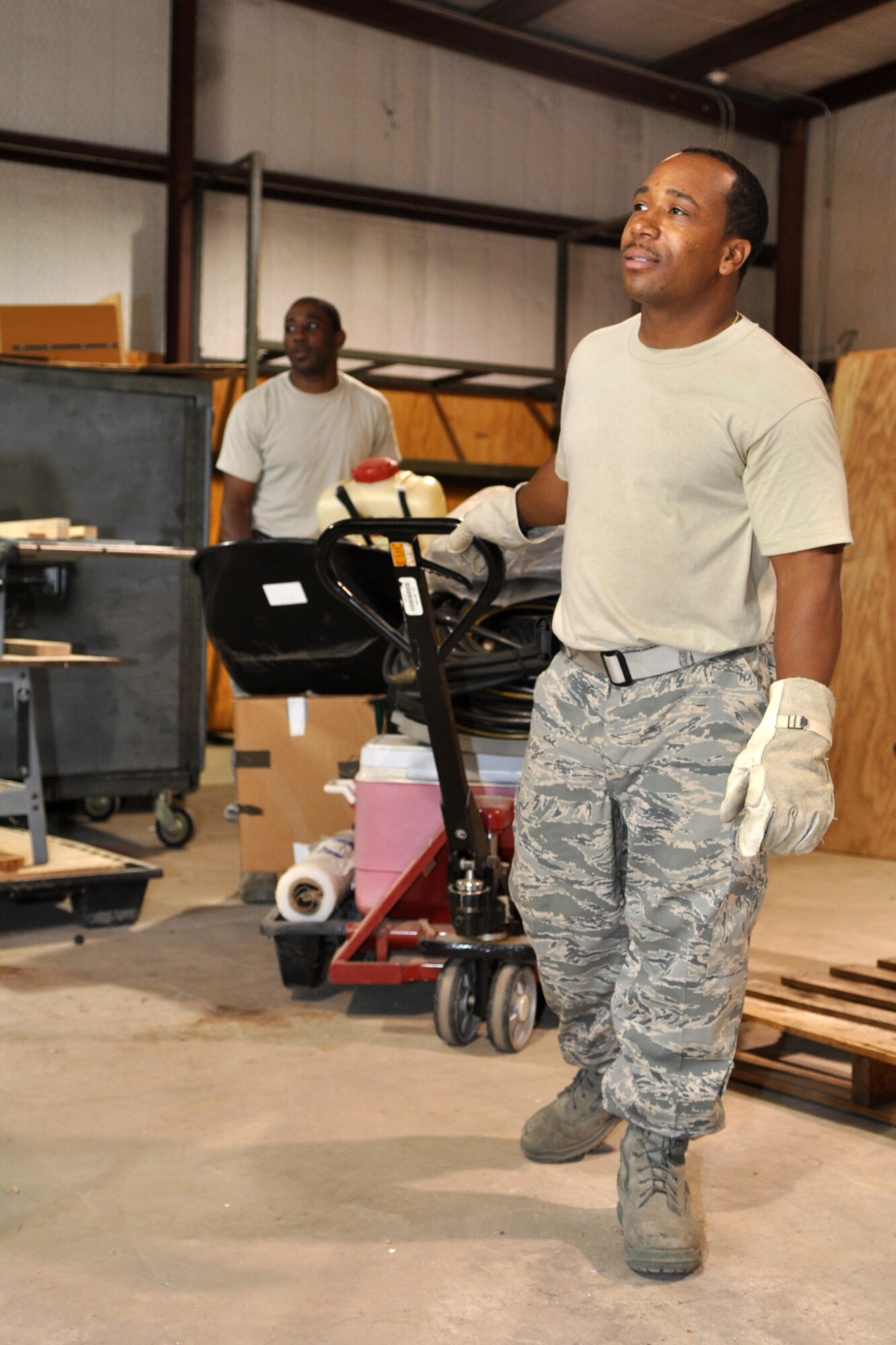 Staff Sgt. Michael Johnson, pest management, and Staff Sgt. Frank Jackson, knowledge operations manager, for the 917th Civil Engineer Squadron wait for a forklift to be moved before they load a conex container with spare parts and equipment for storage at the CE warehouse located behind the 917th Wing Headquarters building at Barksdale Air Force Base, La., August 27, 2009. Room is being made for contractors who will construct training classrooms, a storage area and a bathroom inside the warehouse. The Global Strike Command is paying for the renovation since they will soon occupy the office space the 917th CES recently vacated on base.  Construction is schedule for two weeks and should be completed by the September UTA. (U.S. Air Force photo/Tech. Sgt. Jeff Walston)