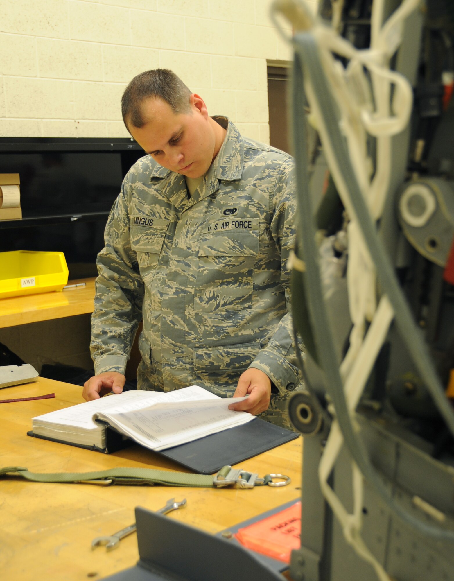 Staff Sgt. Don Mingus, 28th Maintenance Squadron aircrew egress systems journeyman, reads through a technical order manual on an advanced concept ejection seat II here, August 27.  Sergeant Mingus checks proper procedures for working on the ACES II. (U.S Air Force photo/Airman 1st Class Anthony Sanchelli)