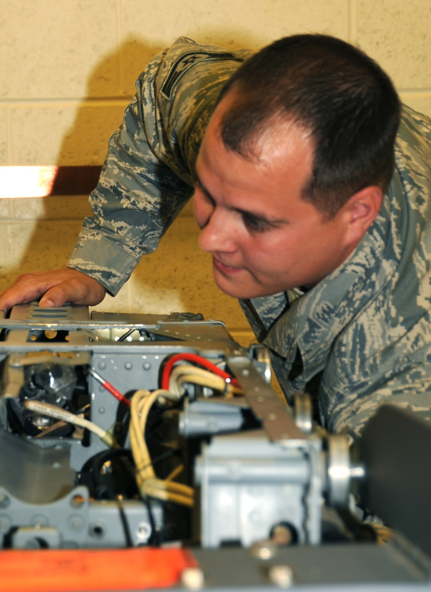 Staff Sgt. Don Mingus, 28th Maintenance Squadron aircrew egress systems journeyman, lifts an advanced concept ejection seat II here, August 27.  Sergeant Mingus lifts the ACES II into a seat lock in order to install an arm strap assembly. (U.S Air Force photo/Airman 1st Class Anthony Sanchelli)
