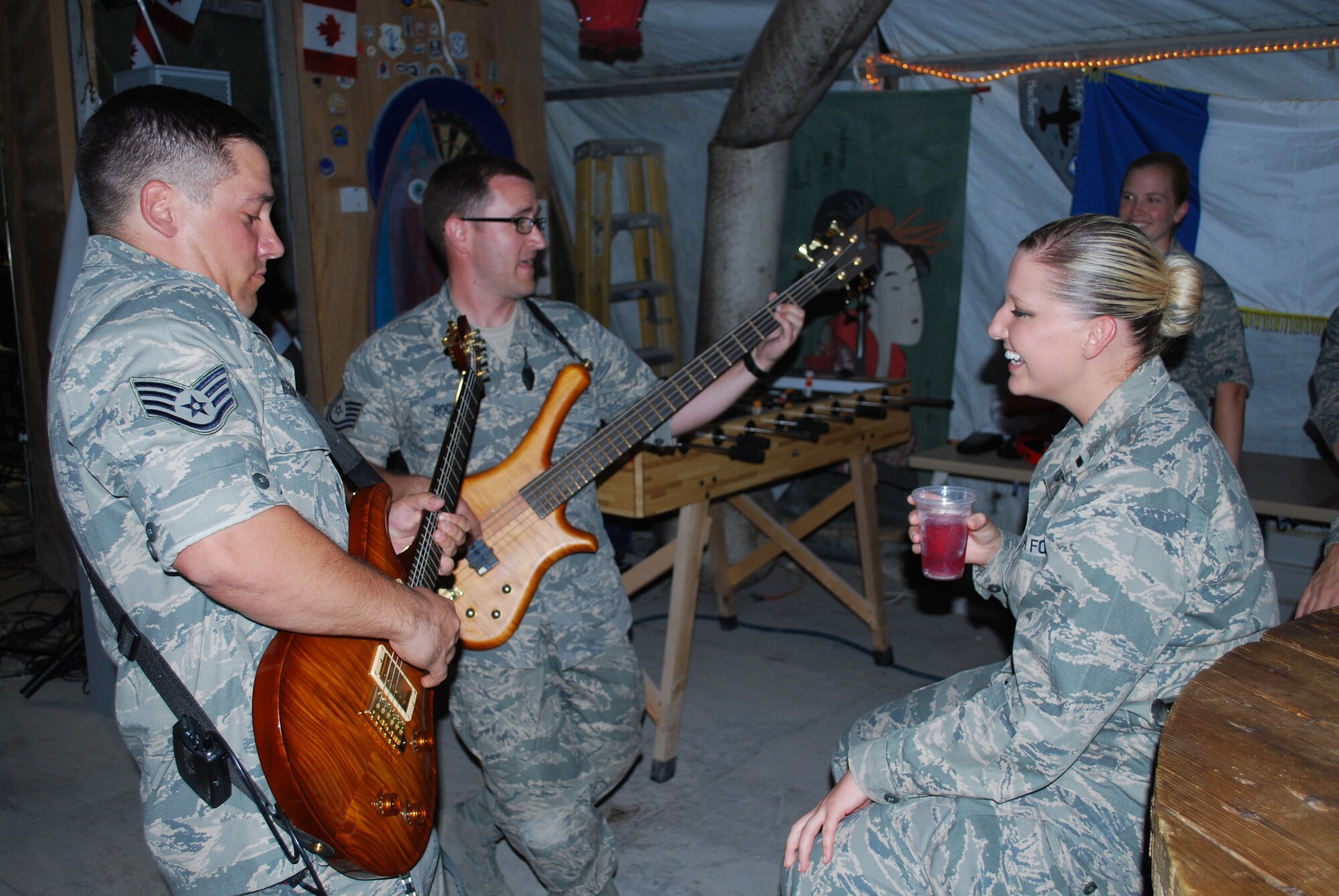 SOUTHWEST ASIA - Staff Sgt. Brian Bigelow (left) and Tech. Sgt. David Rochte (center) get up close and personal with the audience during a concert in Southwest Asia.  The AFCENT Band MOJAVE played an energizing mix of new and old Rock music to give the attending warfighters a break from the stress and strain of serving in a combat zone. The AFCENT Band MOJAVE is made up of members from the Air National Guard Band of the Great Lakes, Swanton, Ohio. (U.S. Air Force photo/Lt. Col. Reid Christopherson)