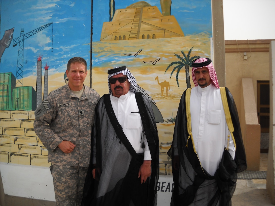 Army Lt. Col. Alan J. Shumate, Sheik Ali al-Manshed al-Ghezi and the sheik’s brother, Sheik Nabeel al-Manshed al-Ghezi, pose for a photo in front of the Iraqi-painted mural in front of the garrison command at Contingency Operating Base Adder, Iraq, Aug. 18, 2009. U.S. Army photo by 2nd Lt. Sophia Volz