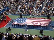 Marines from 6th Communications Battalion, 4th Marine Logistics Group, unfurl an American Flag across the tennis court during the opening ceremony for the U.S. Open at USTA Billie Jean King National Tennis Center, New York City. This is the 127th year of the annual tennis tournament. (Official Marine Corps photo by New York City Public Affairs Office)
