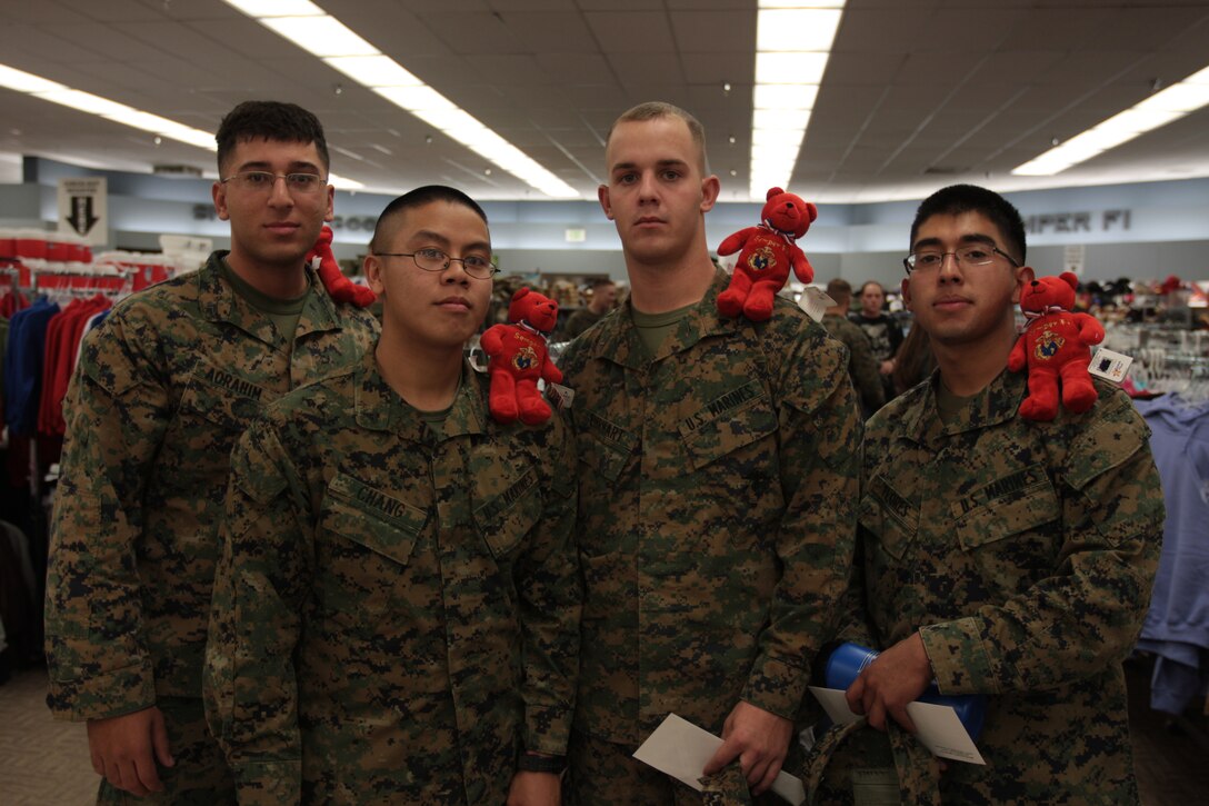 Cpl. Joey Aorahim and Lance Cpls. Casey Chang, Michael Ehrart and Jorge Flores, all radio technicians with 3rd Combat Engineer Battalion, show off their Semper Fi bears they found for the scavenger hunt during the Single Marine Program Shopping Night Dec. 1. Out of the six bears hidden throughout the store, four of them were found by Marines from the 3rd CEB.
