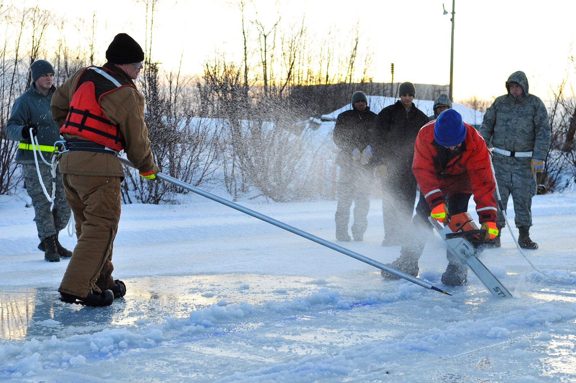 Matt Gore and Scott Caple cut out blocks of ice to demonstrate construction of a trench during a training scenario that focused on oil spills Dec. 1, 2009, Eielson Air Force Base, Alaska. Trenches can be used for diverting and funneling oil into a pit for recovery and containment operations. Mr. Gore and Caple are assigned to the Navy Supervisor of Salvage and Diving, Fort Richardson, Alaska. (U.S. Air Force photo/Staff Sgt. Christopher Boitz)