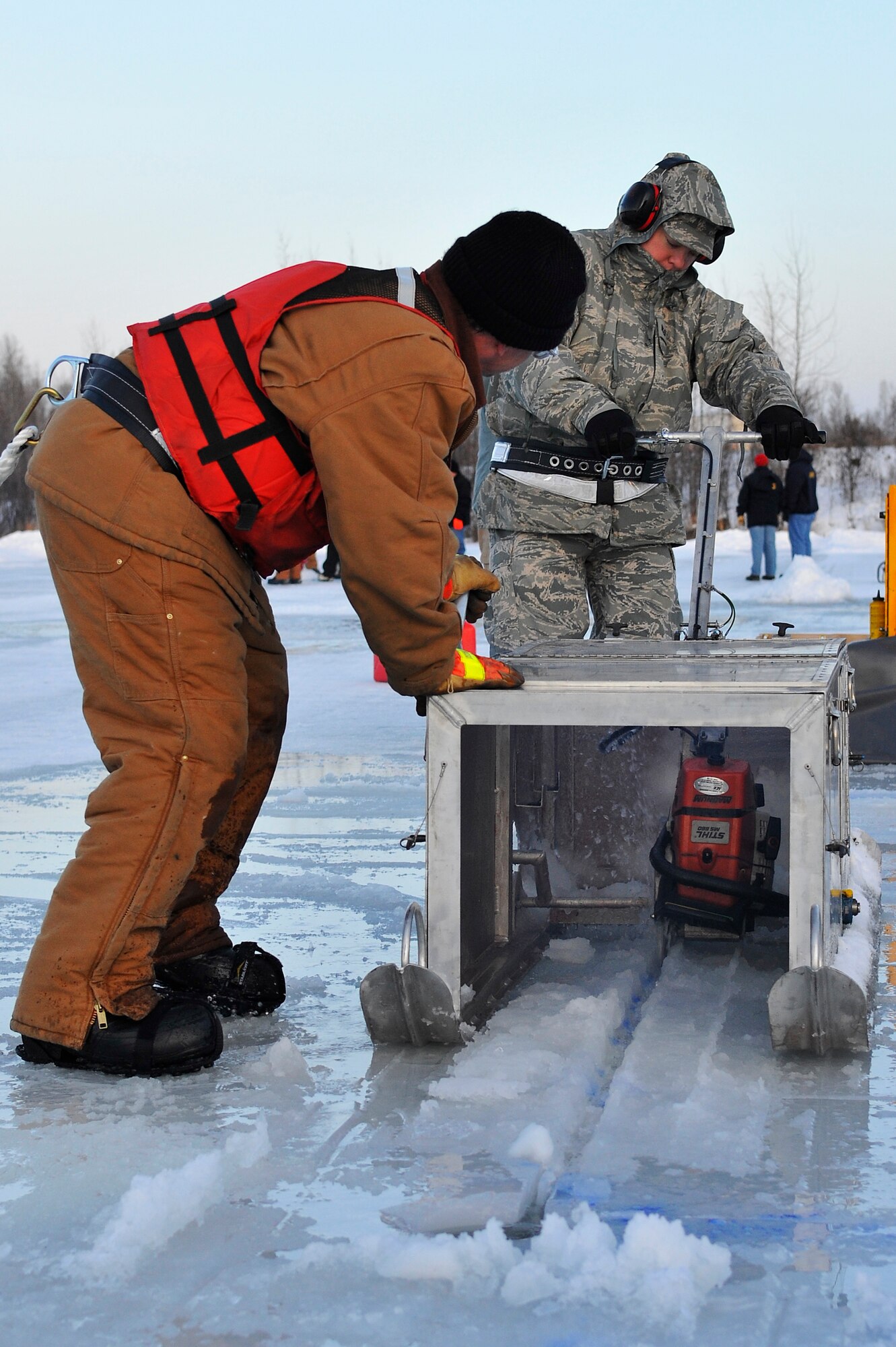 Tech. Sgt. Gary Lutz and Matt Gore use an ice cutter to make blocks of ice for constructing a trench during a training scenario that focused on oil spills Dec. 1, 2009, Eielson Air Force Base, Alaska. Trenches can be used for diverting and funneling oil into a pit for recovery and containment operations. Sergeant Lutz is assigned to the 354th Logistics Readiness Squadron. Mr. Gore is assigned to the Navy Supervisor of Salvage and Diving, Fort Richardson, Alaska. (U.S. Air Force photo/Staff Sgt. Christopher Boitz)